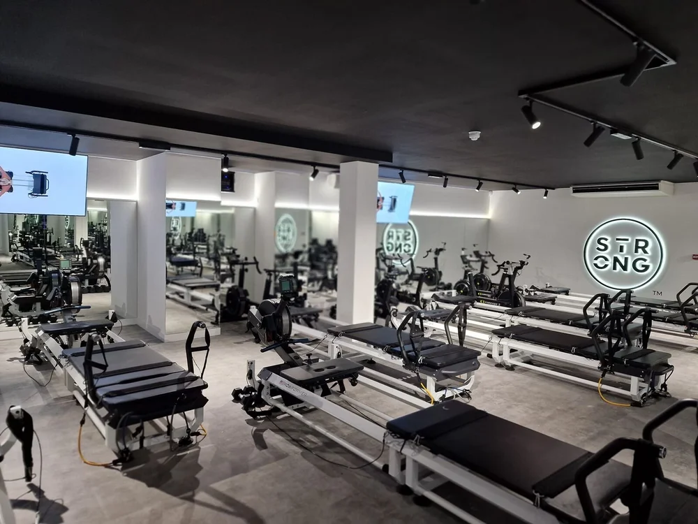 Strong Pilates studio with LED track lighting and the illuminated round logo lit, Leicester