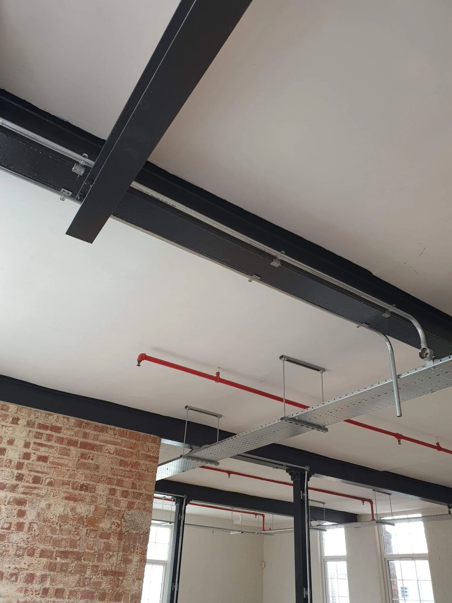 Steel cable tray run across an exposed ceiling