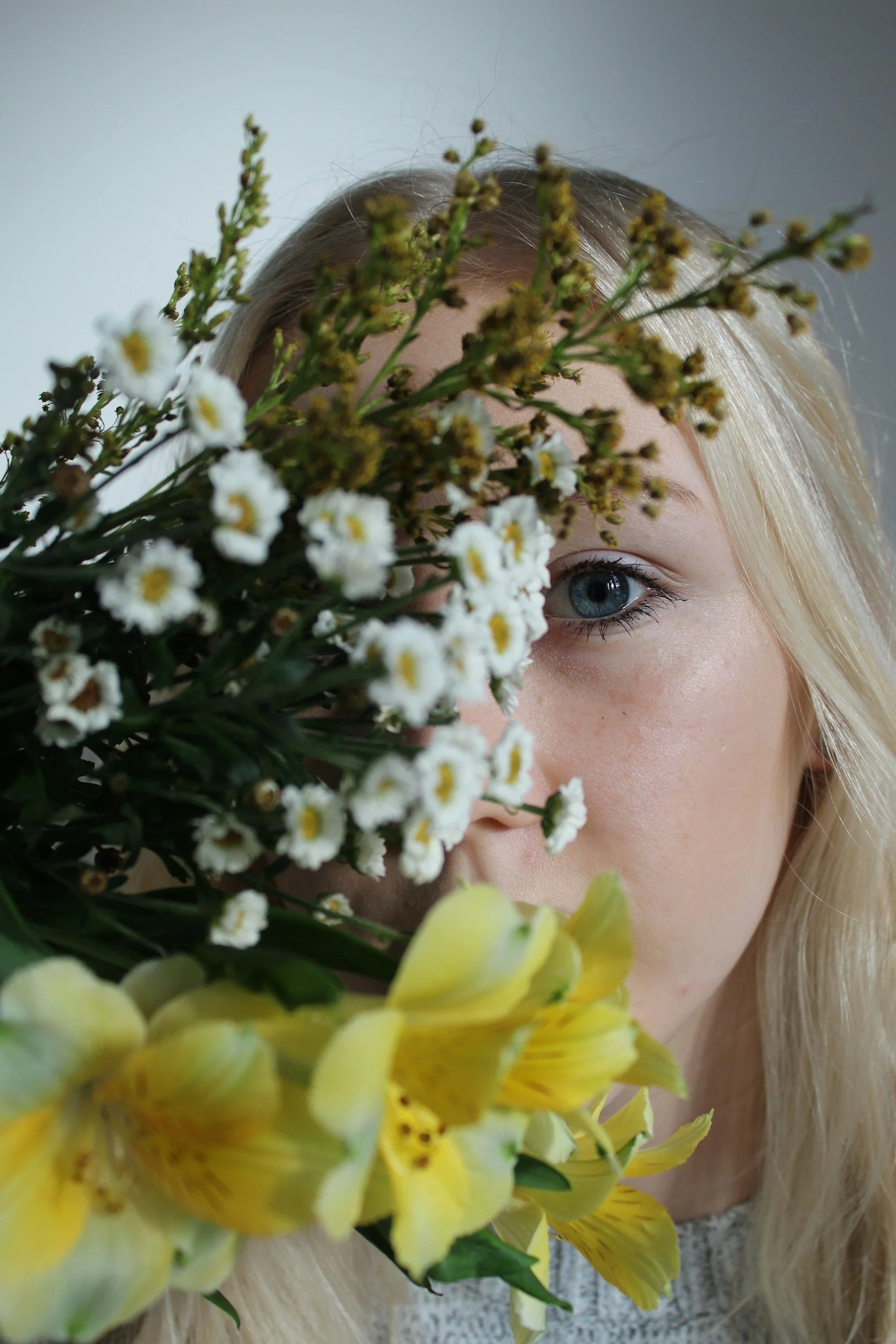 An elderly woman and a younger woman sitting close together, comforting each other during an emotional moment, with the younger woman covering her face with her hands.