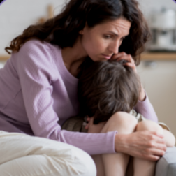 Asian young mother in violet shirt comforting her crying daughter