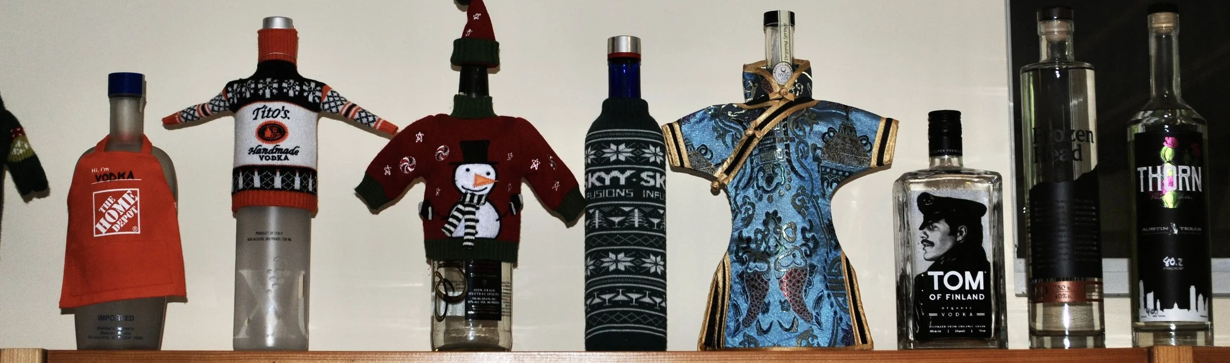 (some bottles still dressed up from our Ugly Sweater Vodka Tasting party) Home Depot apron – Kutskova, 
Titos sweater – Uvix, 
Snowman sweater – Cristall, 
Skyy sweater – Skyy strawberry, 
Peranakan Sarong – Dripping Springs, 
Tom of Finland, 
Frozen