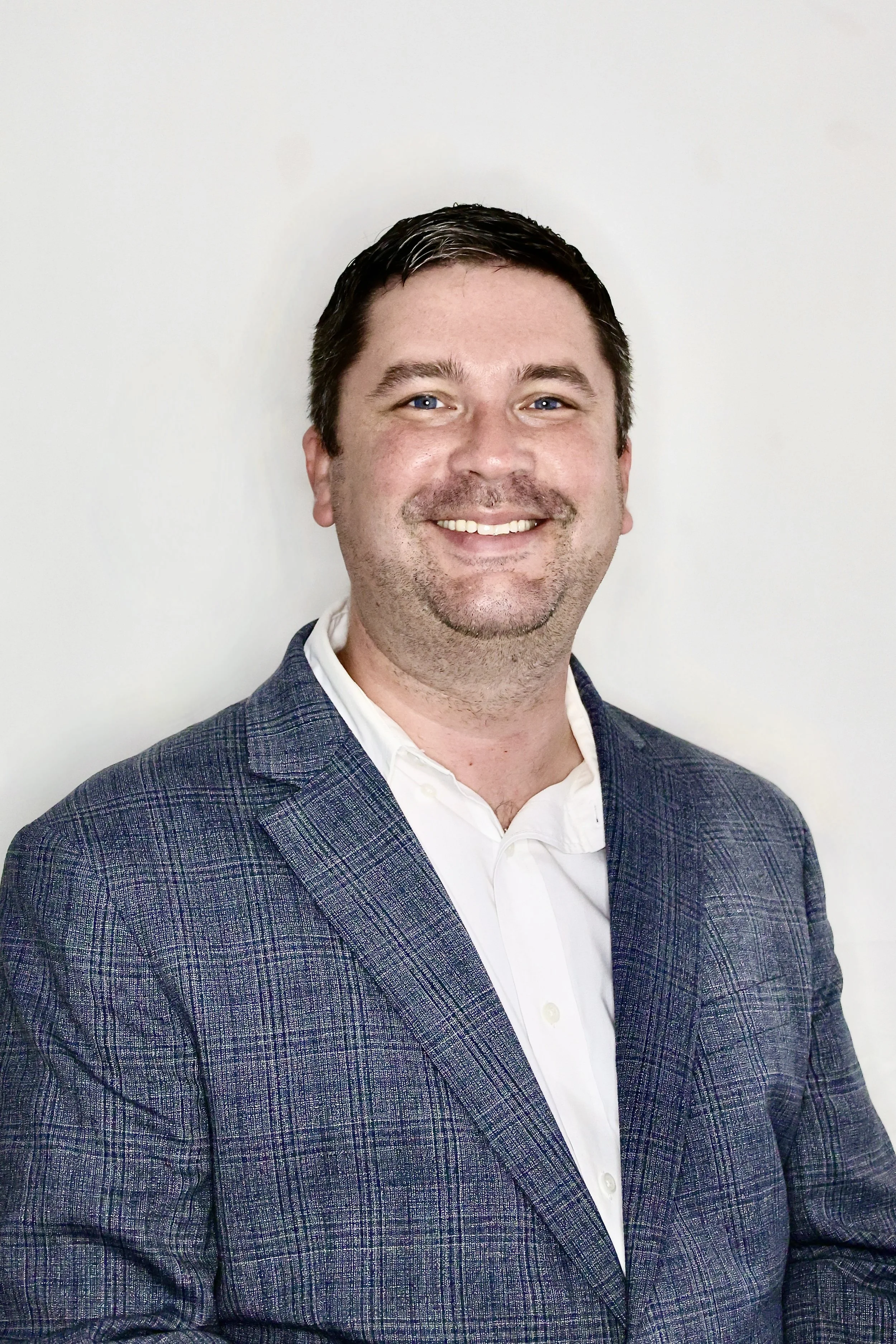 Mark Stankiecize, President and CEO, smiling wearing a suit with a boutonniere.