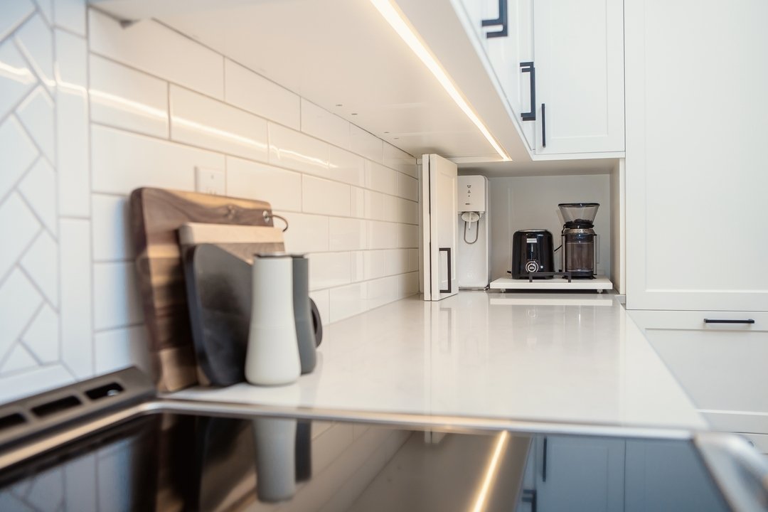 Corners can be tricky when it comes to optimizing your kitchen storage space. To be honest, we often try to limit them when possible. This one came together well with a blind corner cabinet up top and then an appliance garage with a bifold door on th