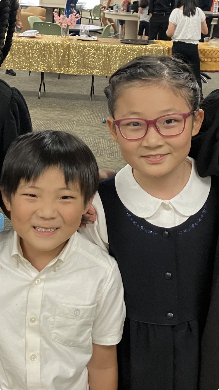 brother and sister in elementary school smiling at a reception after a piano studio recital in Chapel Hill North Carolina U.S.A.