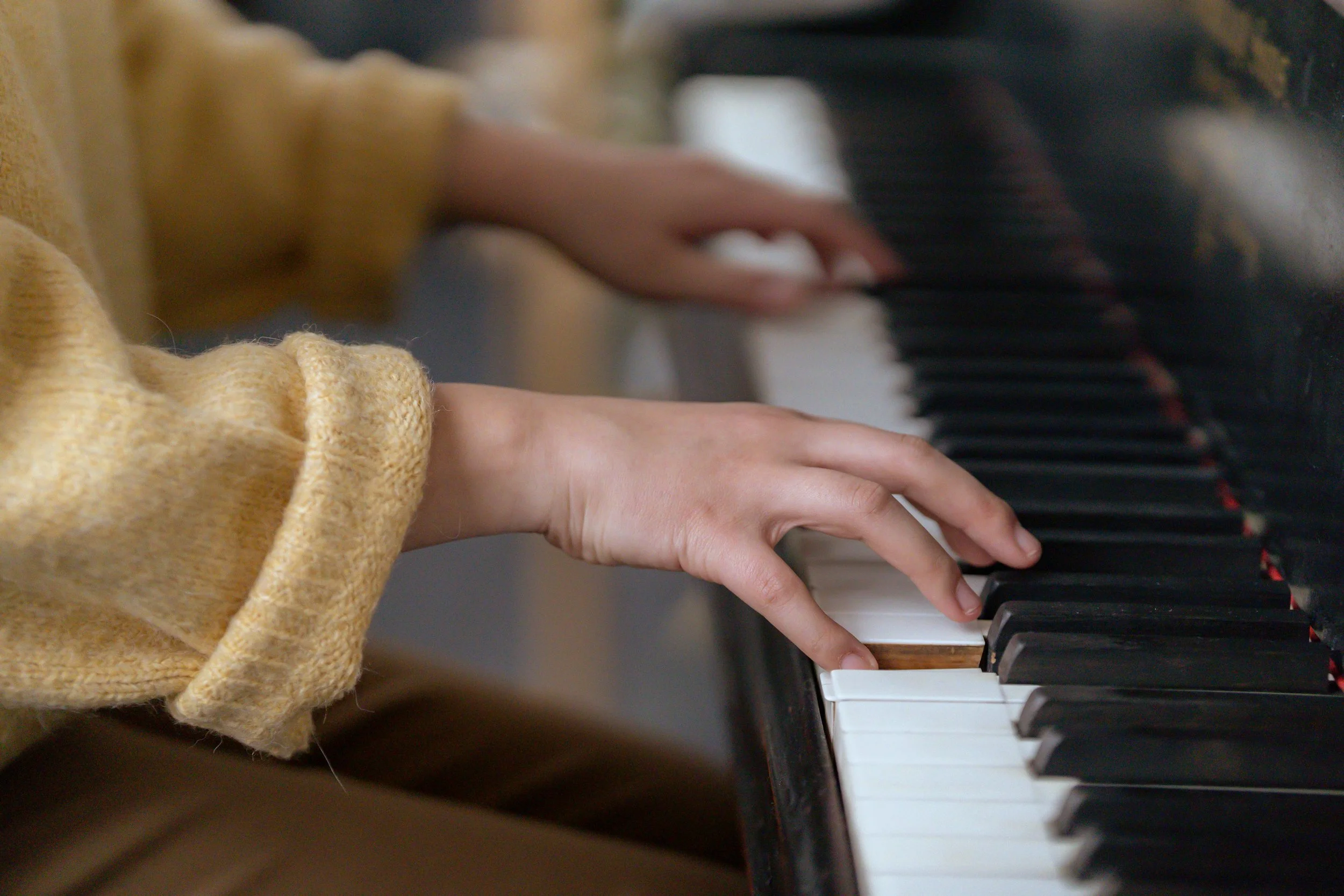 right hand playing the keys on a piano during an online piano lesson with a bilingual piano teacher in Japanese and English
