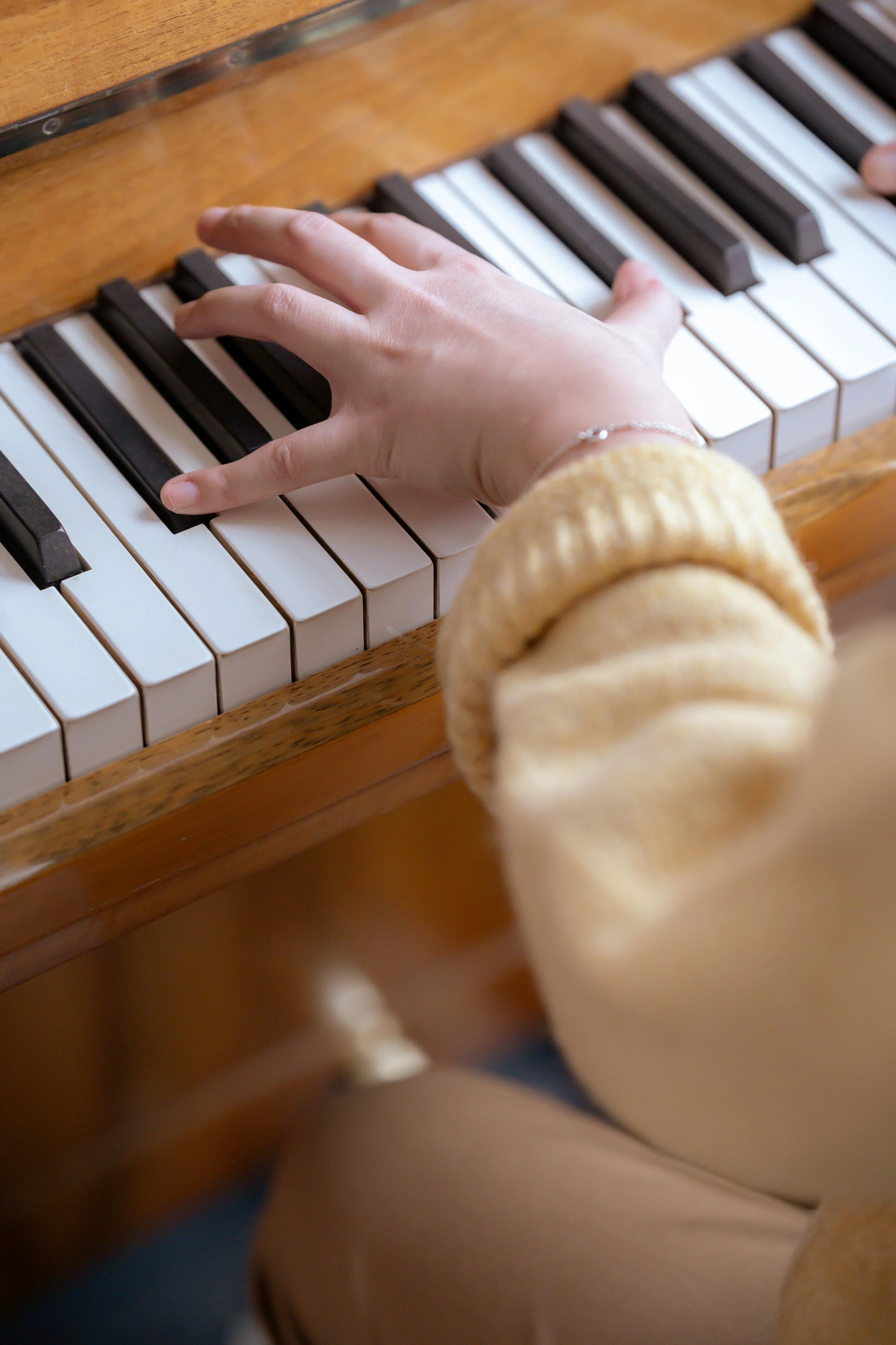 closeup of a child student's hand playing the piano while taking private piano lessons in Yokohama Japan