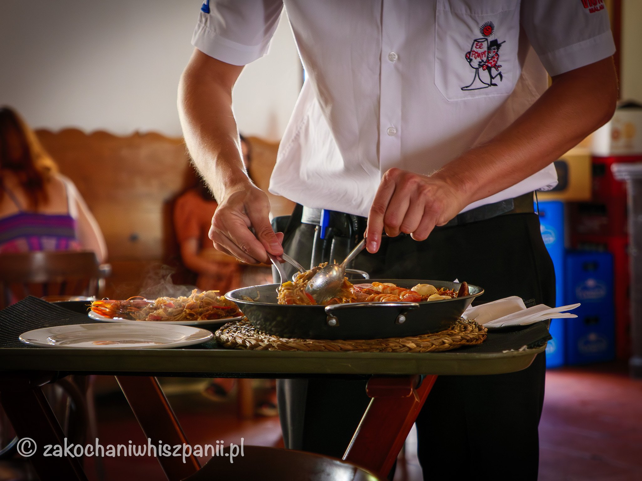 Kelner serwuje paellę w restauracji El Pimpi w Maladze