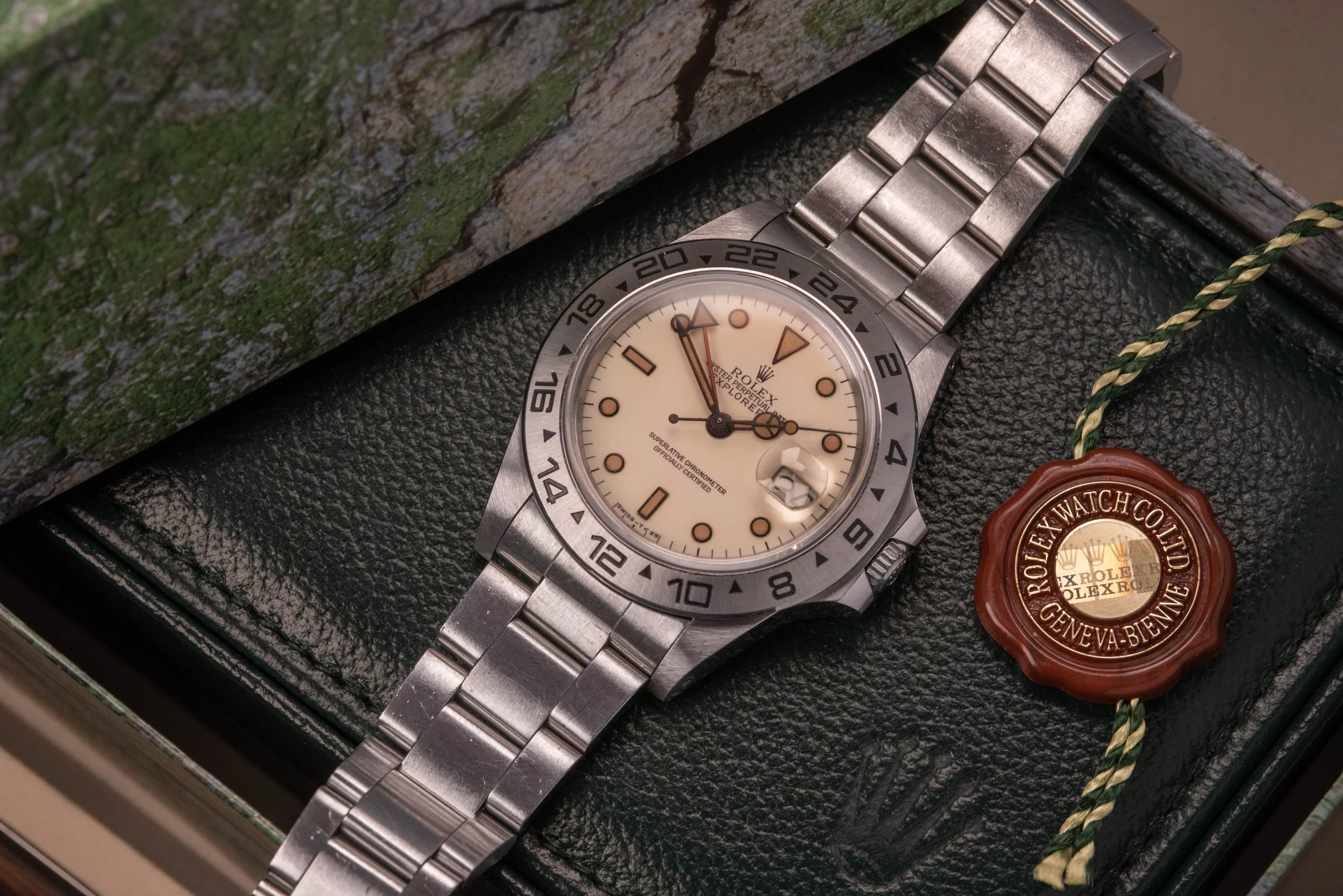 rolex 16550 with creamy panna dial resting on vintage rolex green leather box light from lower left hands at 1:49