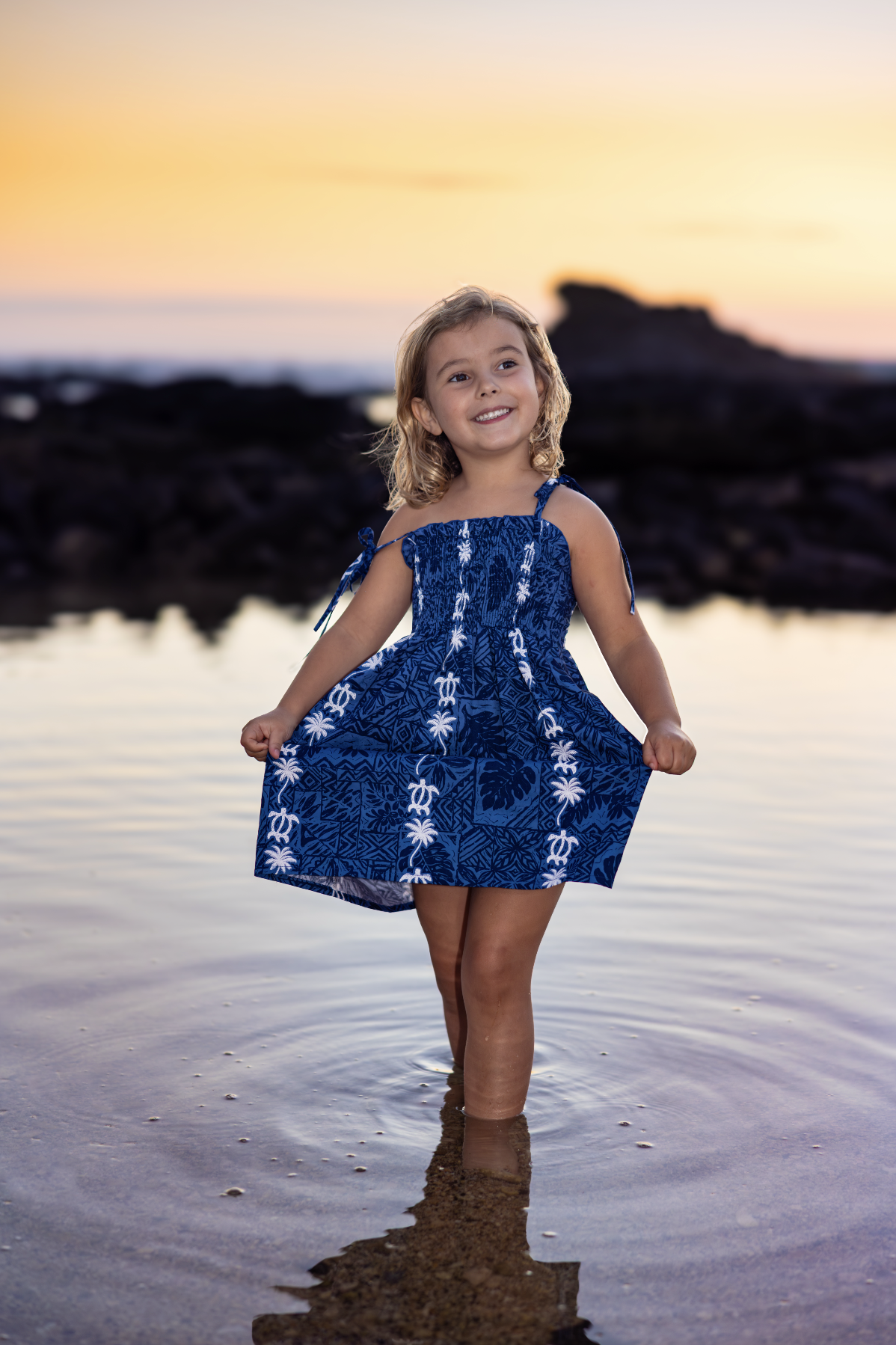 Young girl taking a photo portrait on beach at sunset in Hawaii with CynthiArtistry, also known as Cynthia Buckles. Cynthia Buckles is rated the best photographer on the Big Island of Hawaii with over 50 5 star reviews with luxury companies.