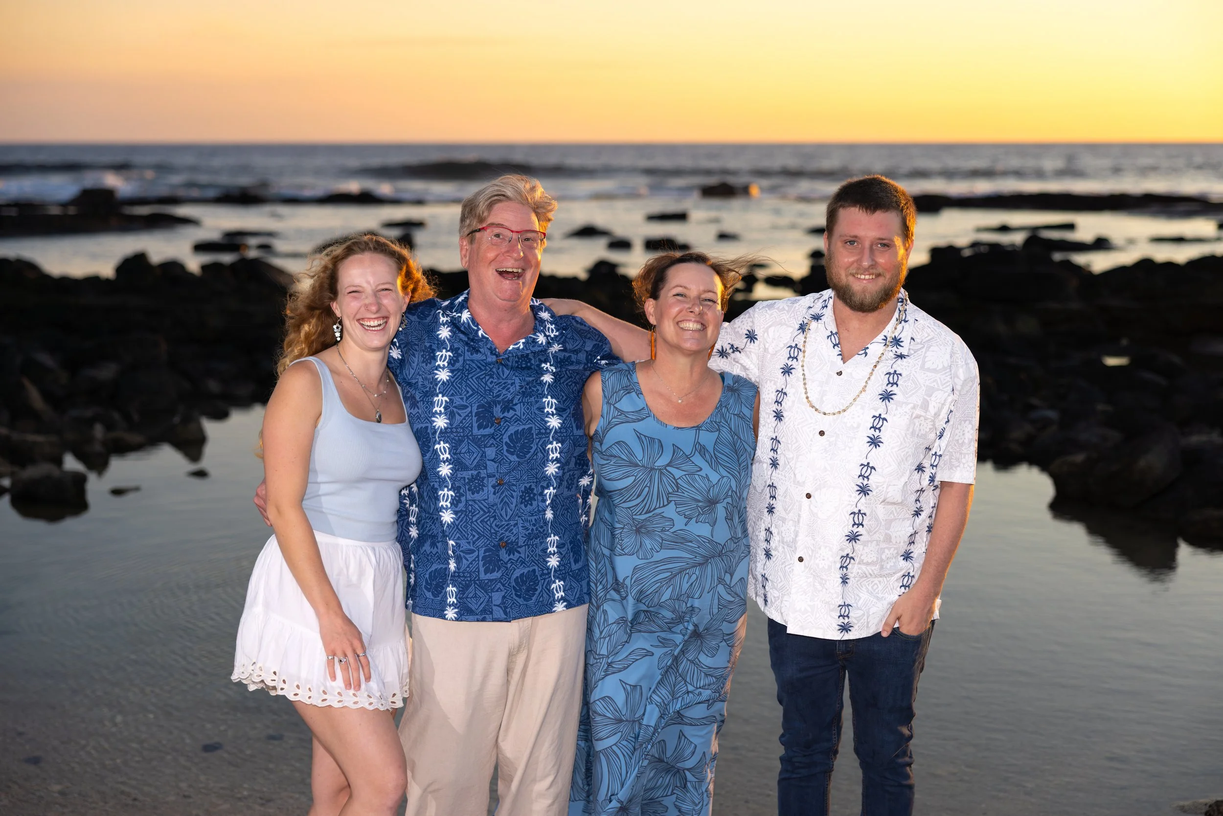 Family of five smiling on the beach at sunset having a wonderful time on the Big Island of Hawaii near Kona with their amazing family photographer Cynthia Buckles, the best photographer in Hawaii! Cynthia Buckles company is CynthiArtistry.