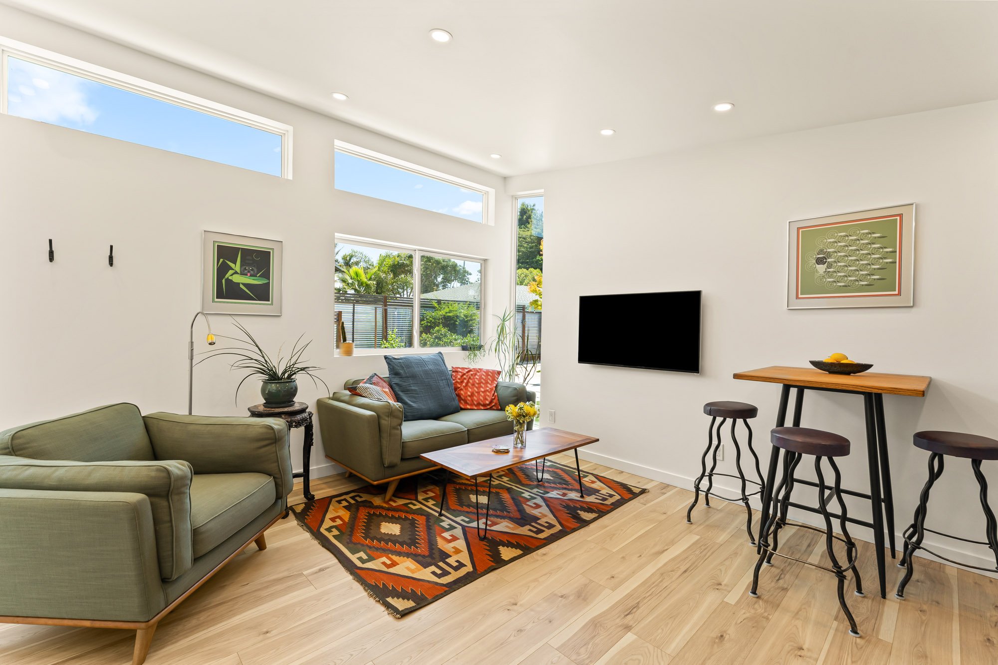 Bright ADU living room featuring vaulted ceilings, expansive windows, and an open floor plan for comfortable everyday living.