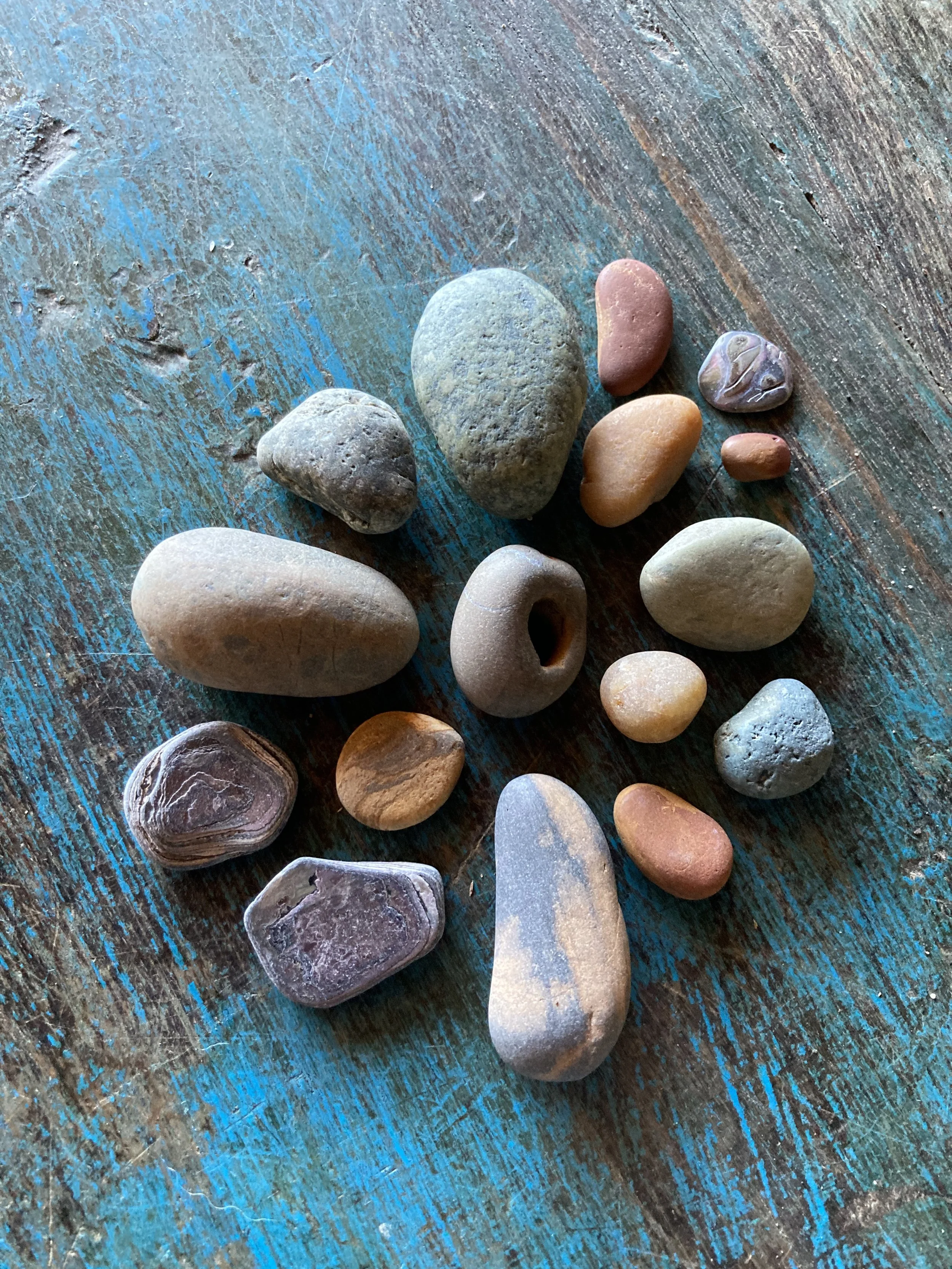 Colored stones arranged on a wooden tabletop.tabletop.