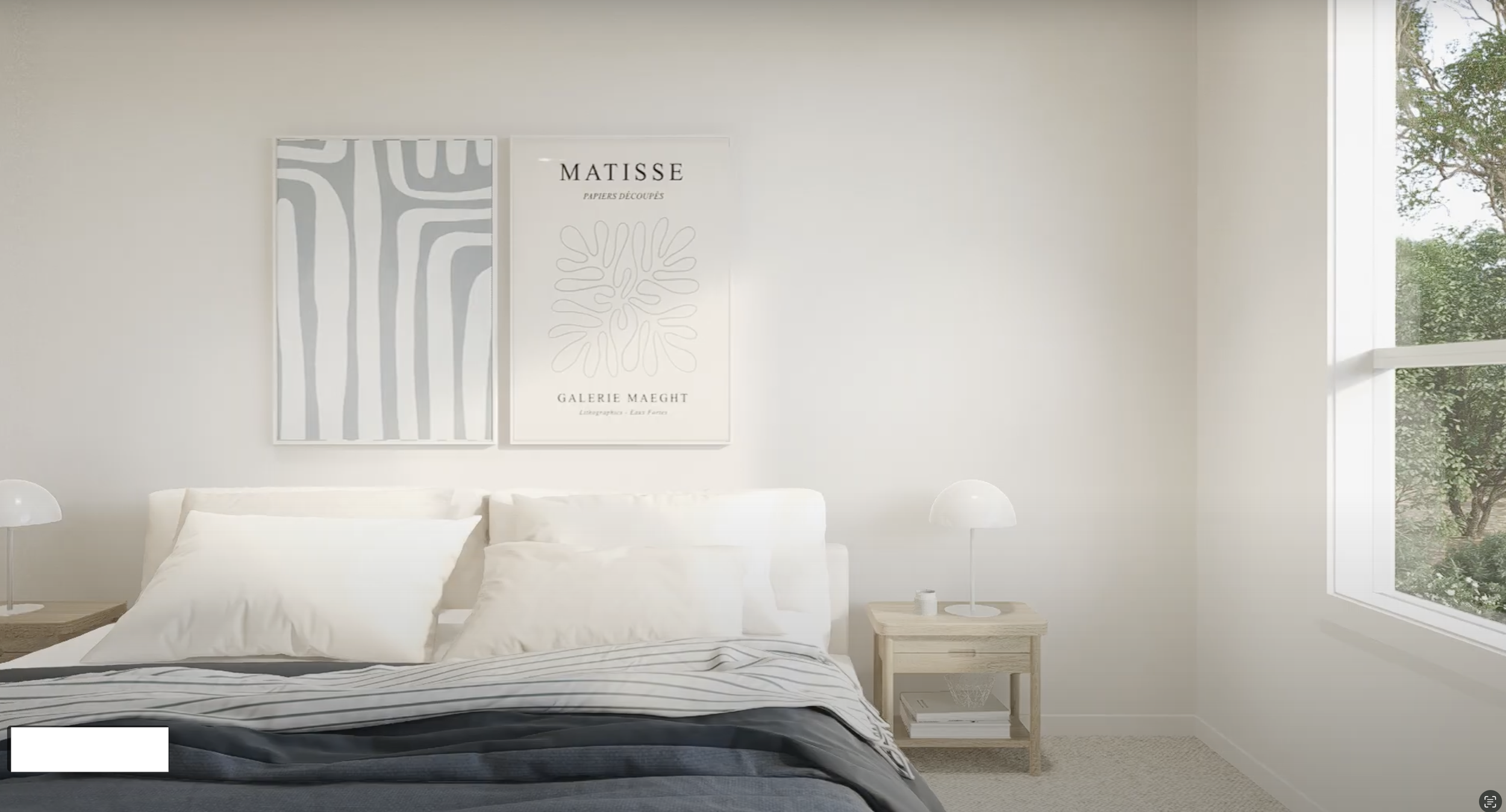 A minimalist bedroom with white walls, a large window showing green trees outside, and two framed art prints on the wall. The bed has white pillows and a black-and-white striped blanket, with two small wooden nightstands on either side, each holding a white lamp.