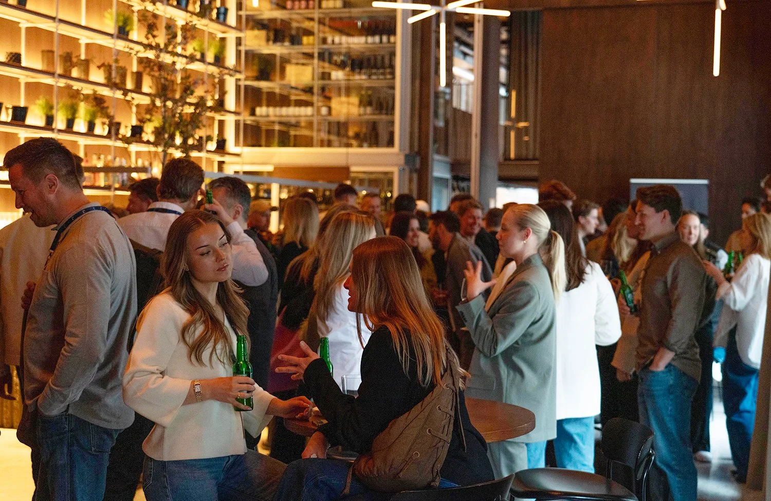 Folk som snakker sammen og drikker øl i Hallen, et av selskapslokalene til Trekanten i Oslo.