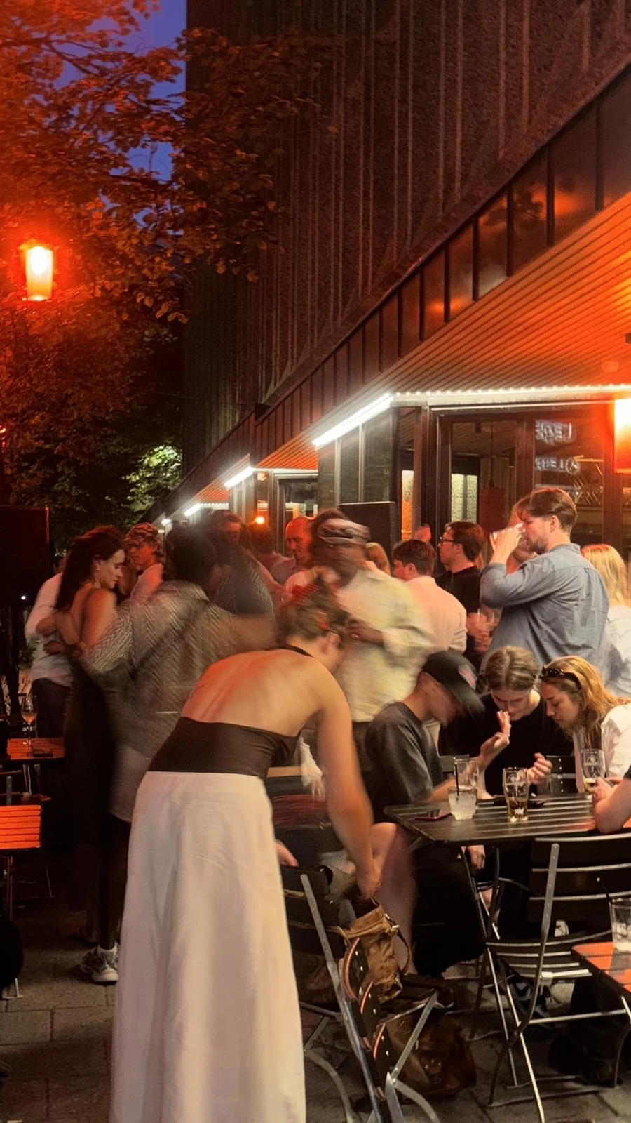 Folk som koser seg en sommerkveld på uteserveringen til Trekanten