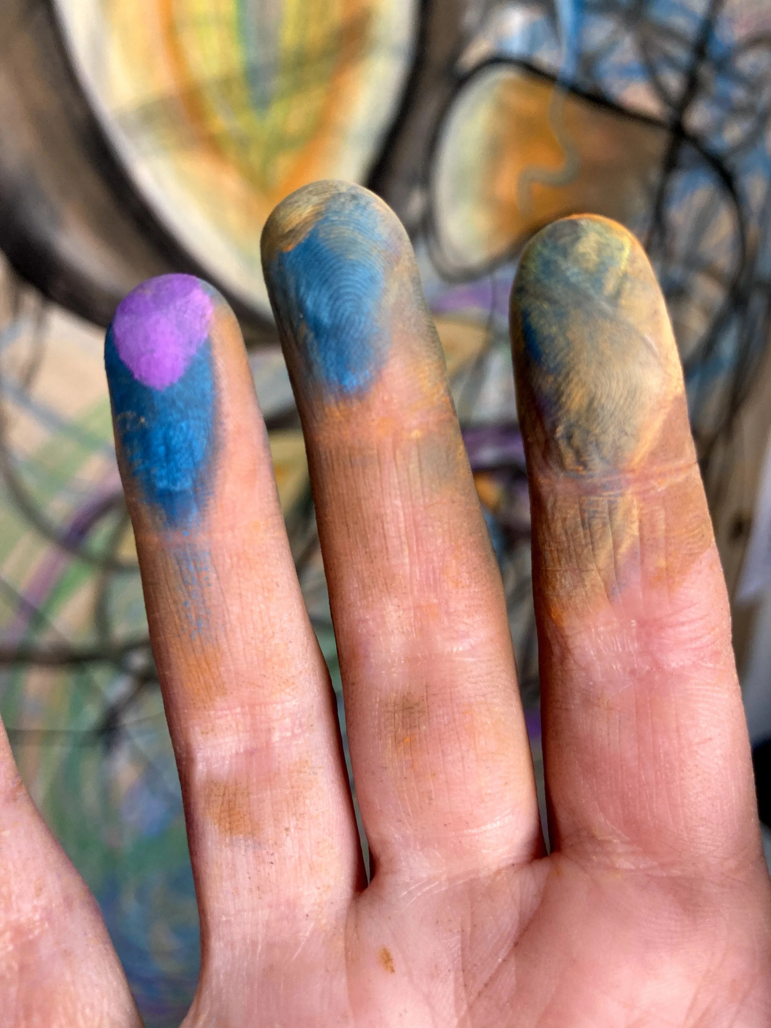 close up of hand with pastel dust covering finger tips after an art therapy sessoin