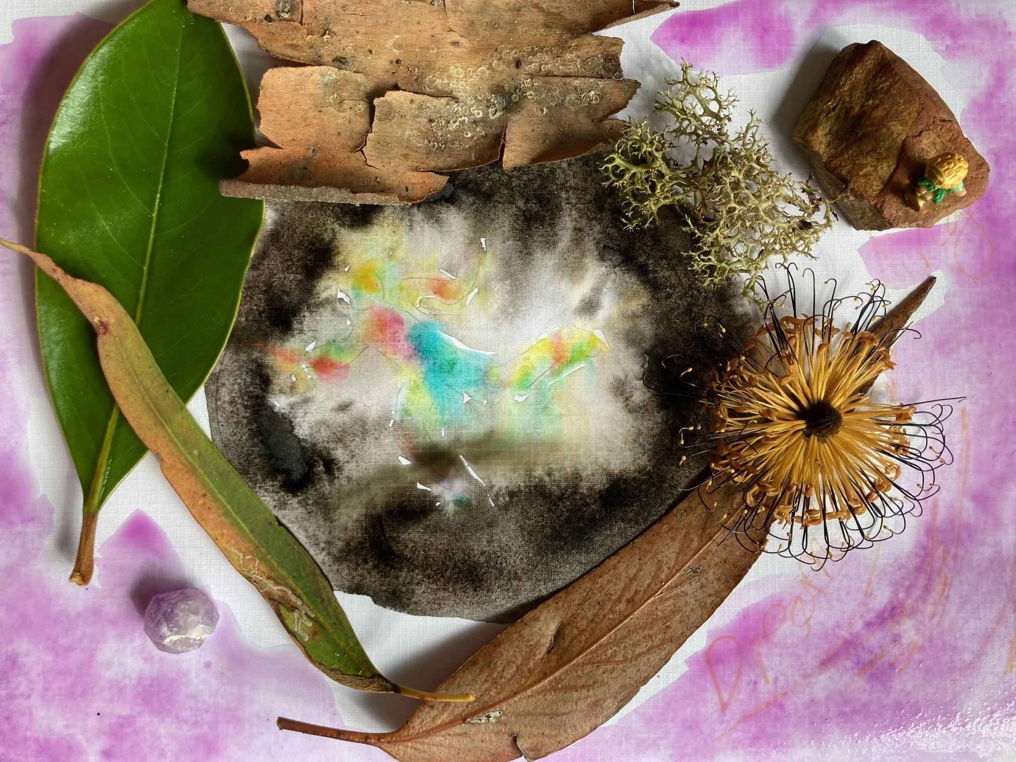photograph of artwork creating a nest made of leaves for the colour watercolour artwork in the middle