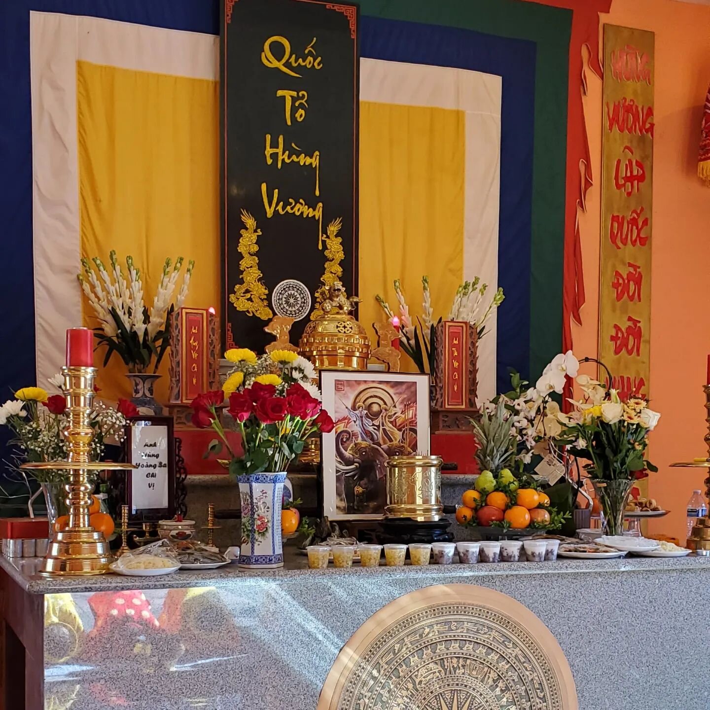 Honoring Hai B&agrave; Trưng, the Trung Sisters of Vietnam. #Vietnameseculturalcenter #westseattle [Image of ancestral altar with reflection on marble base of elders bowing during ceremony with their red and yellow &aacute;o d&agrave;i against the ma