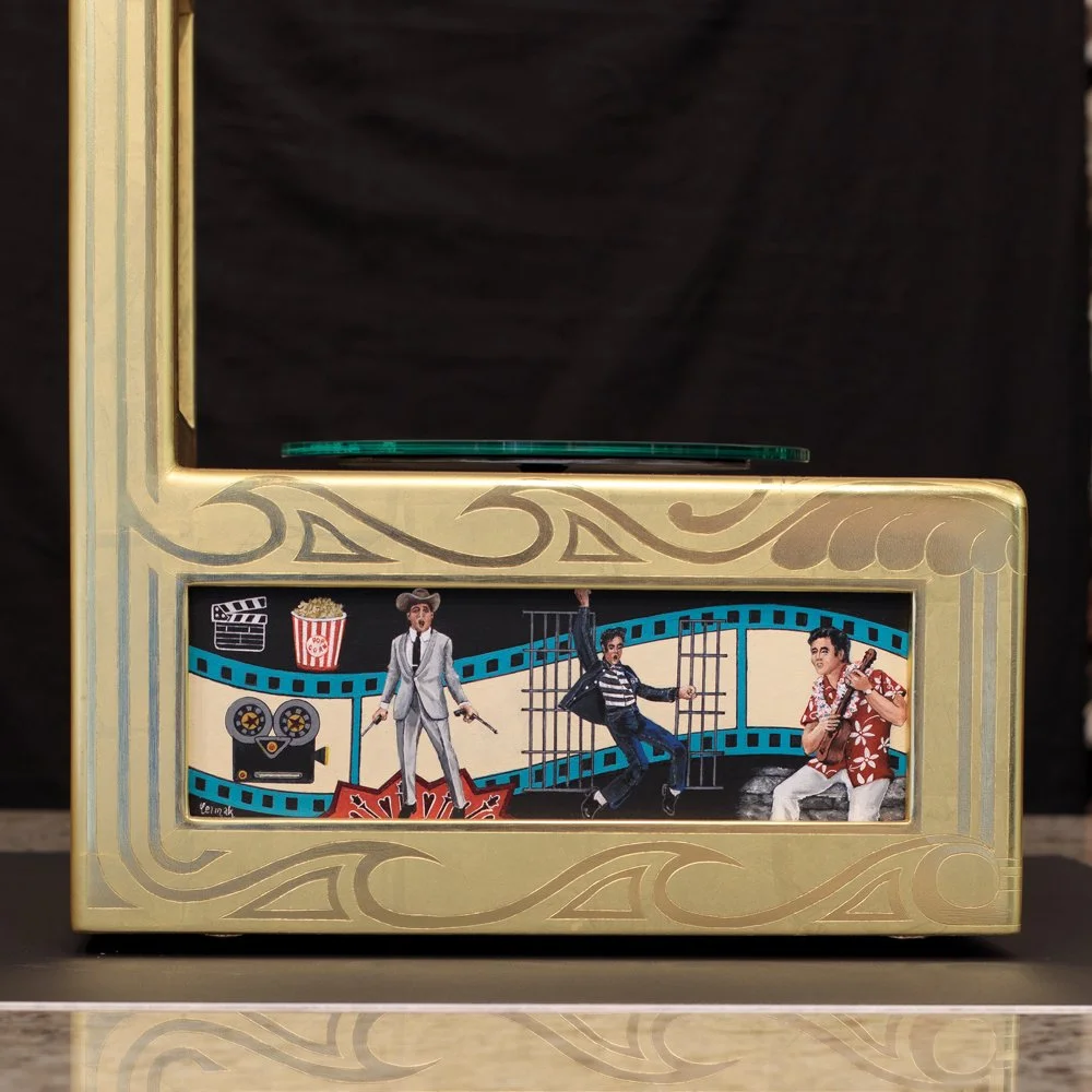 The panels were designed to illustrate the varied public personas of Elvis Presley.  This panel depicts his role as a Hollywood star.  His roles in movies Paradise, Jailhouse Rock, and Viva Las Vegas decorate this side panel.