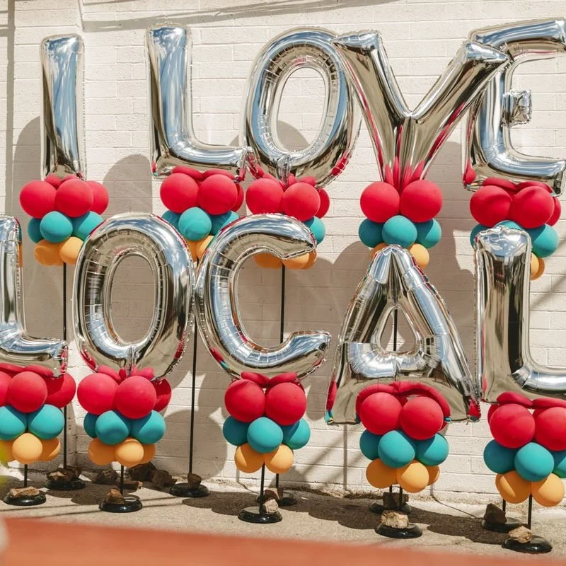 Balloons at an event that say "I love local"
