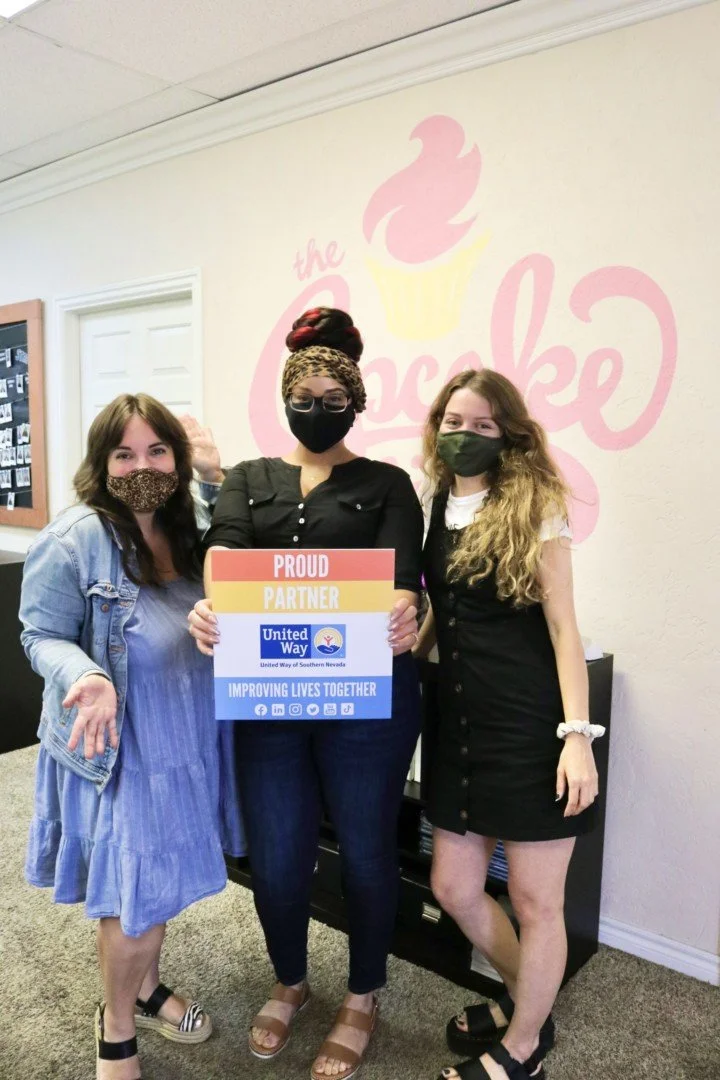 3 staff holding United Way Proud Partner sign