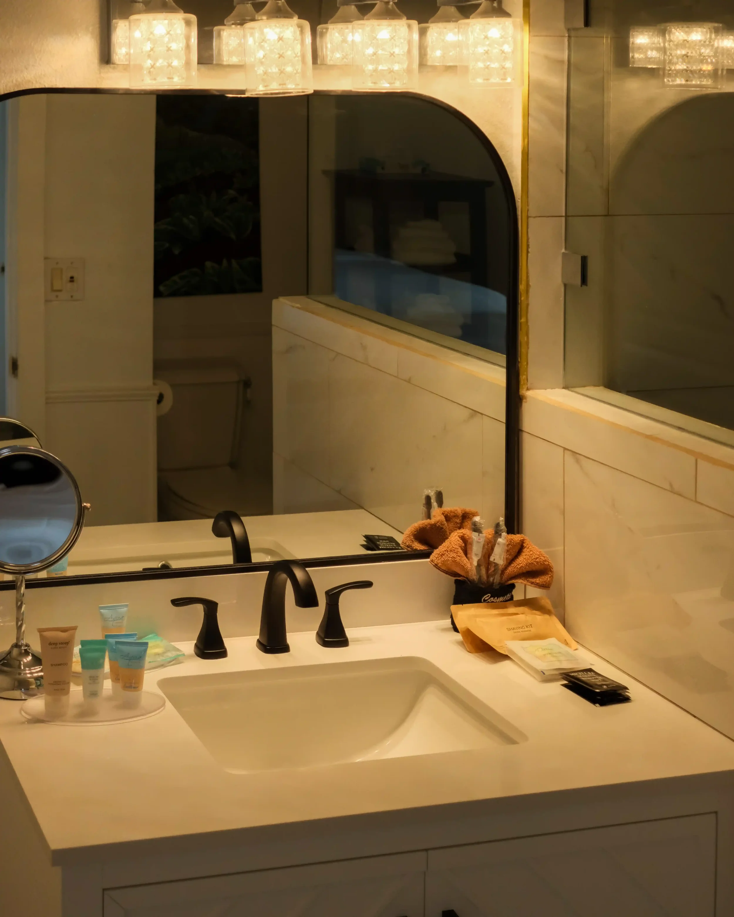  The private bathrooms strip away generic decor in favor of sleek black fixtures, crisp white vanities, and modern glass showers. 