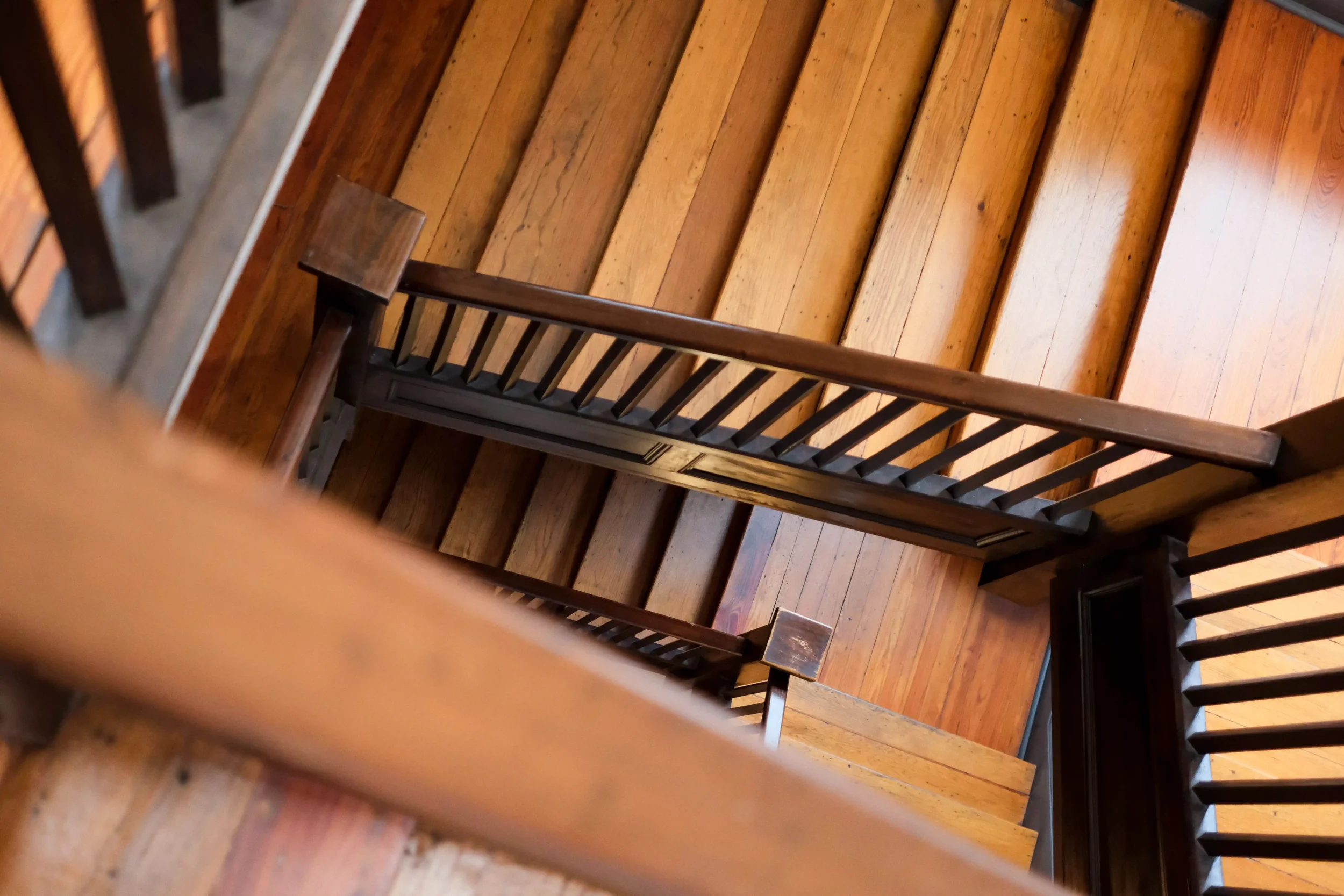  A beautifully restored wooden staircase with dark railings serves as a tactile reminder of the property's enduring century-old heritage. 