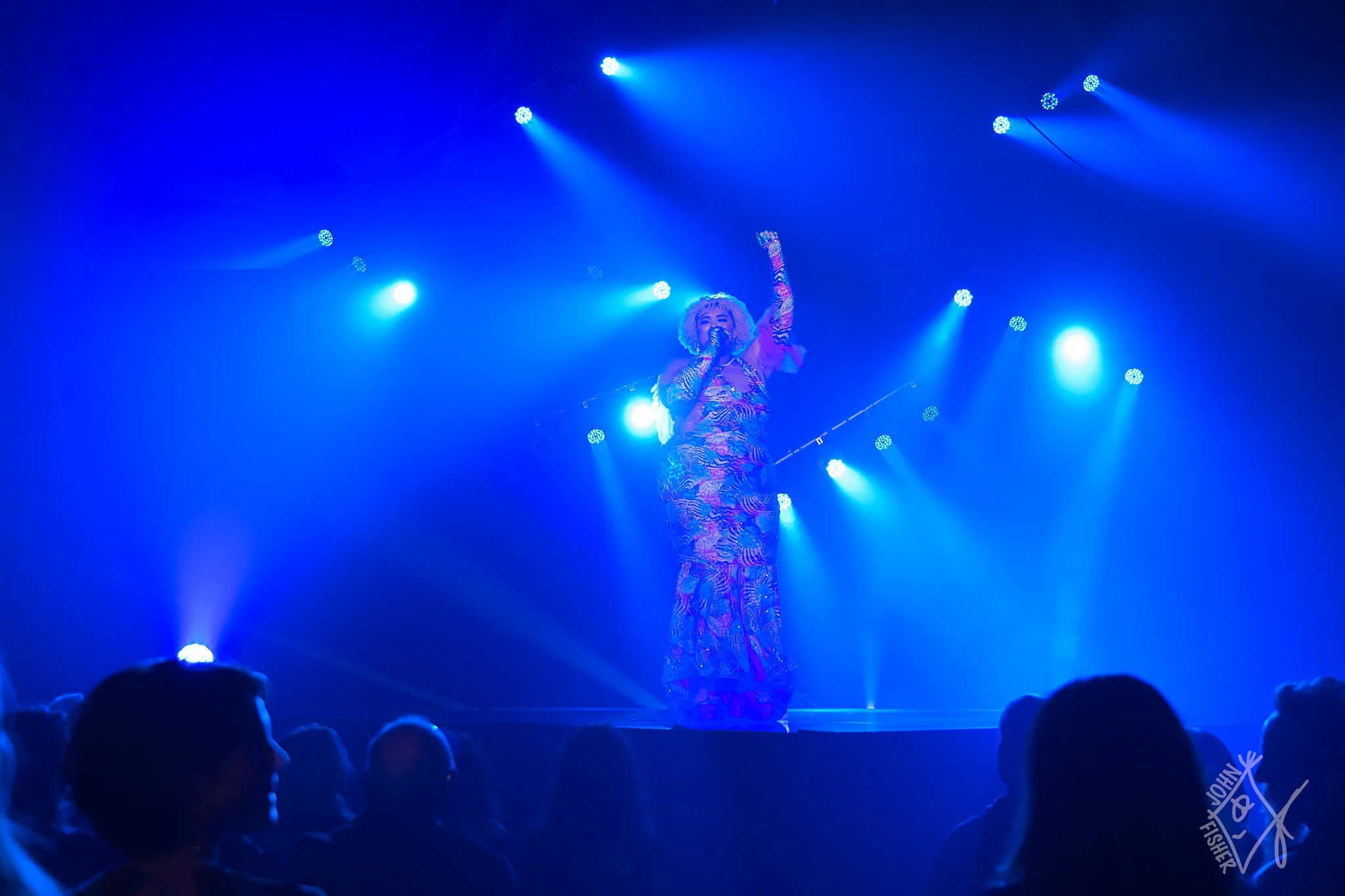 A woman is singing with her hand raised