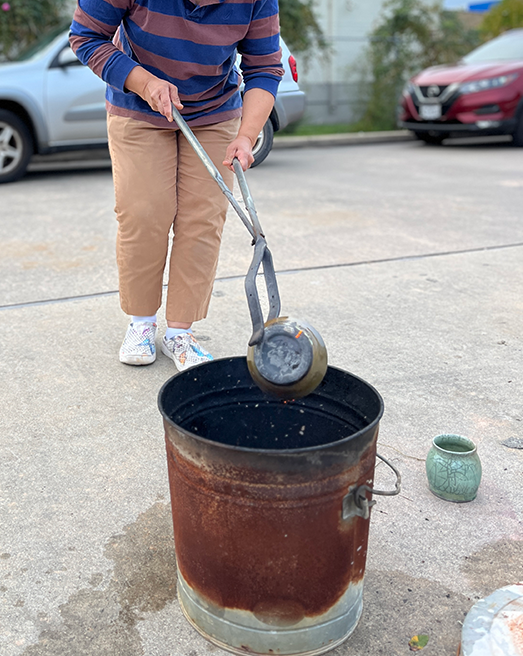 Artist Transferring Piece from Kiln to Can