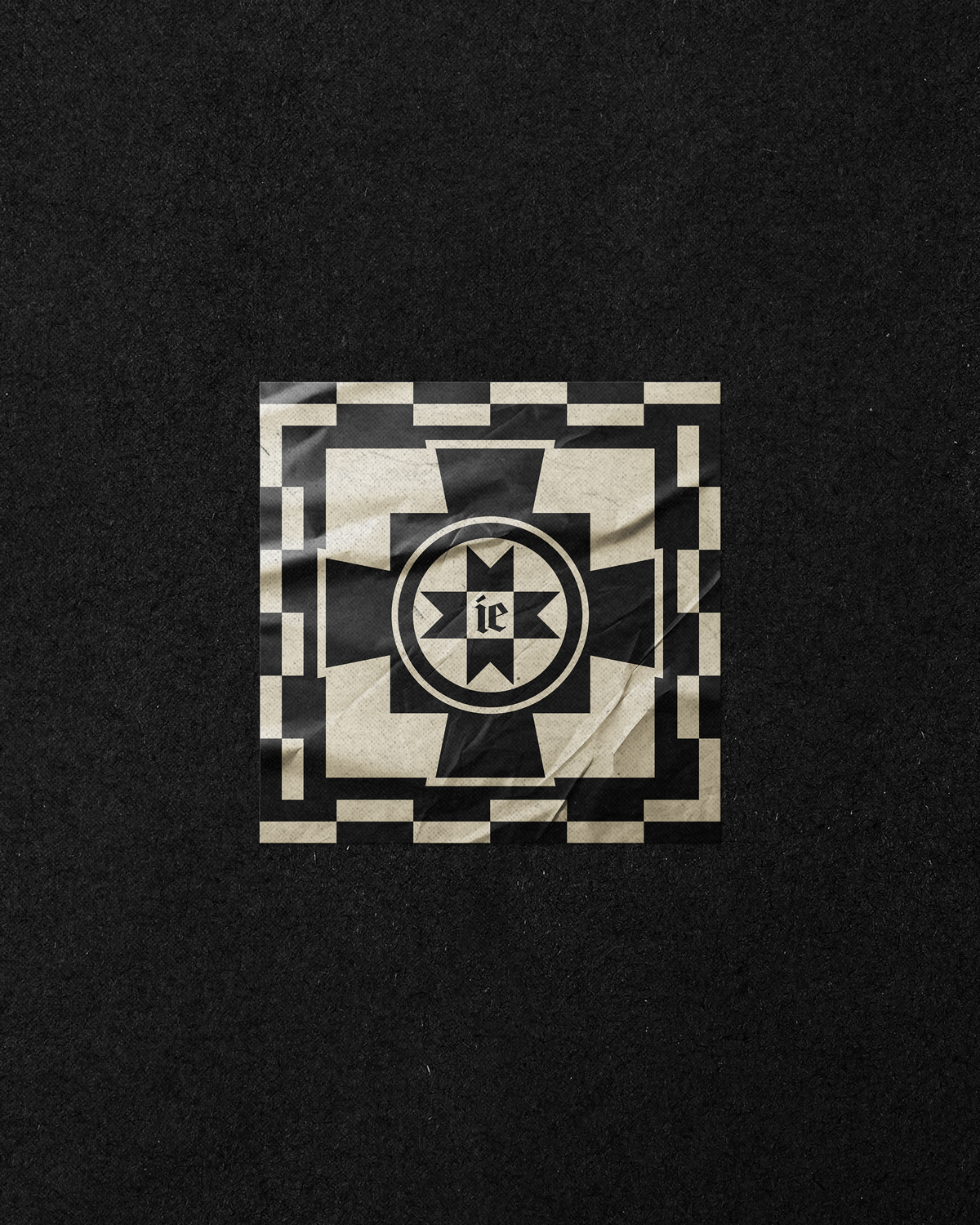 Black and white geometric design with a central star and the letters "ie" inside the star, on crumpled paper.