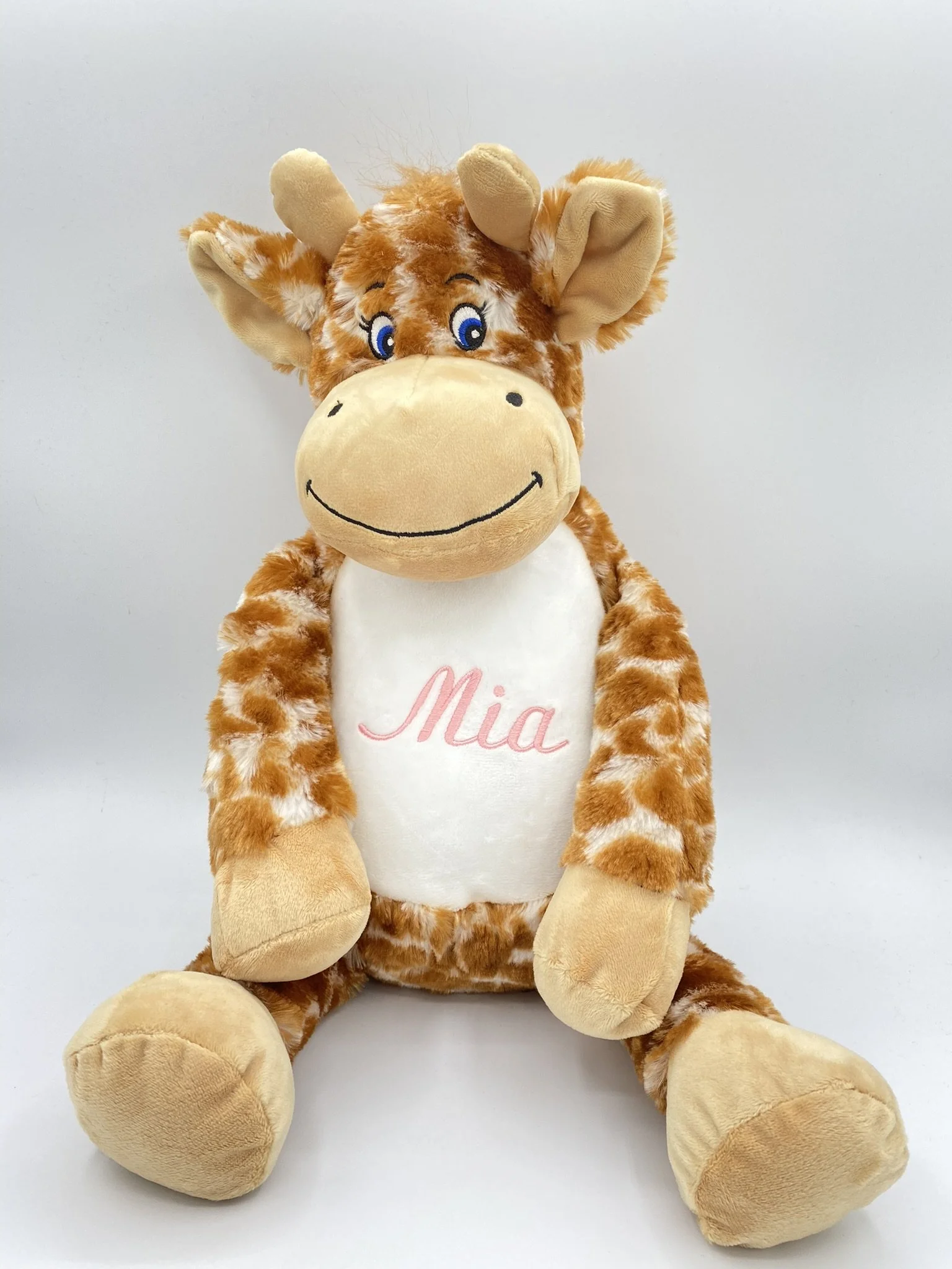 Personalised embroidered giraffe soft toy with the name Mia in pink thread