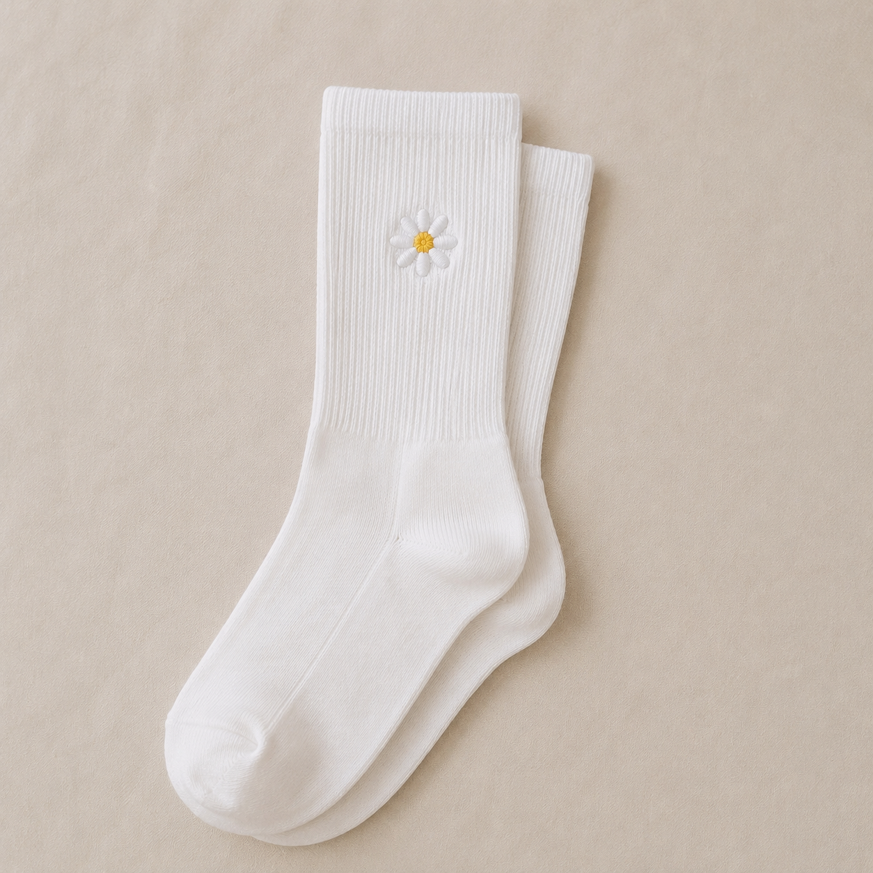 White crew socks with a small embroidered daisy near the cuff.