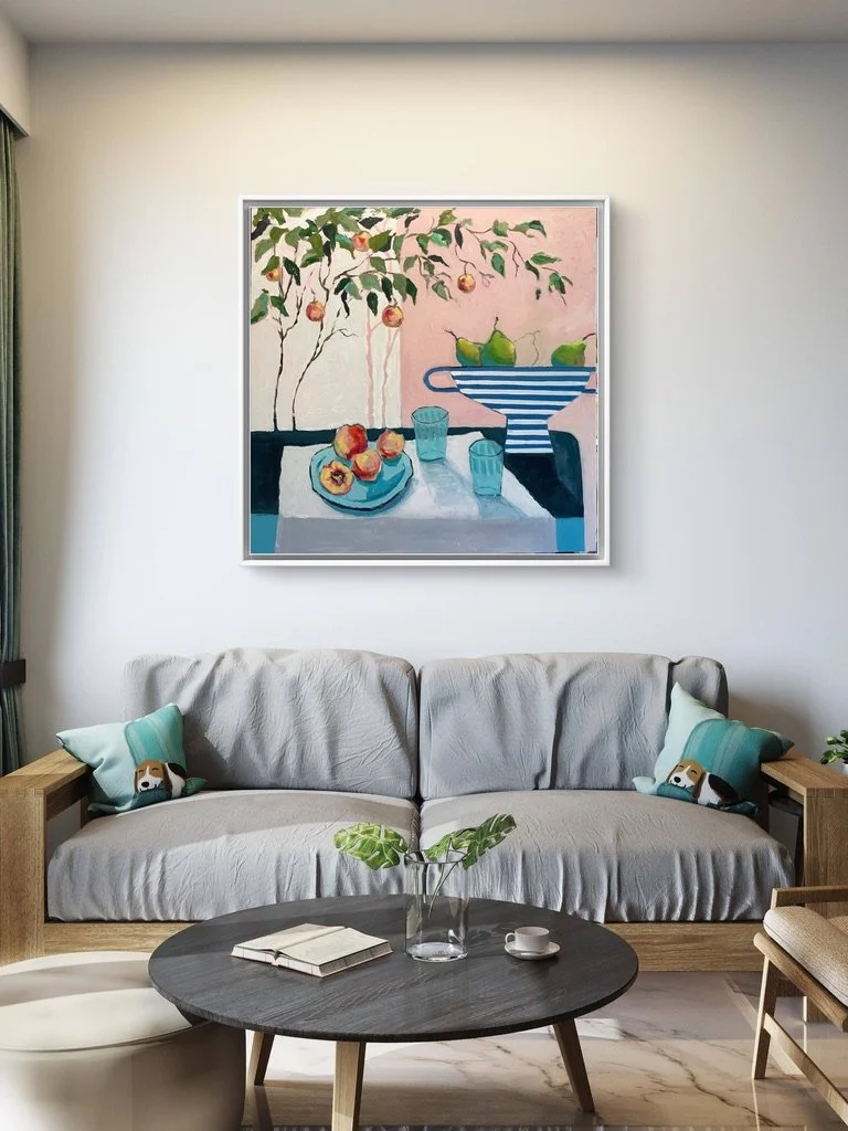 A beautiful painting of peaches and pears on a pink background hanging on a wall behind a sofa