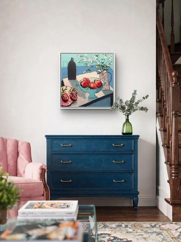 a beautiful, vibrant painting of pomegranates and blossom shown in a lovely home decor setting with a blue painted sideboard