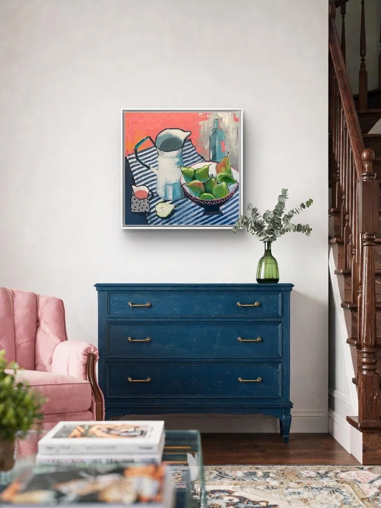 vibrant still life painting in pinks and blues shown hanging on a wall above a pretty blue chest of drawers