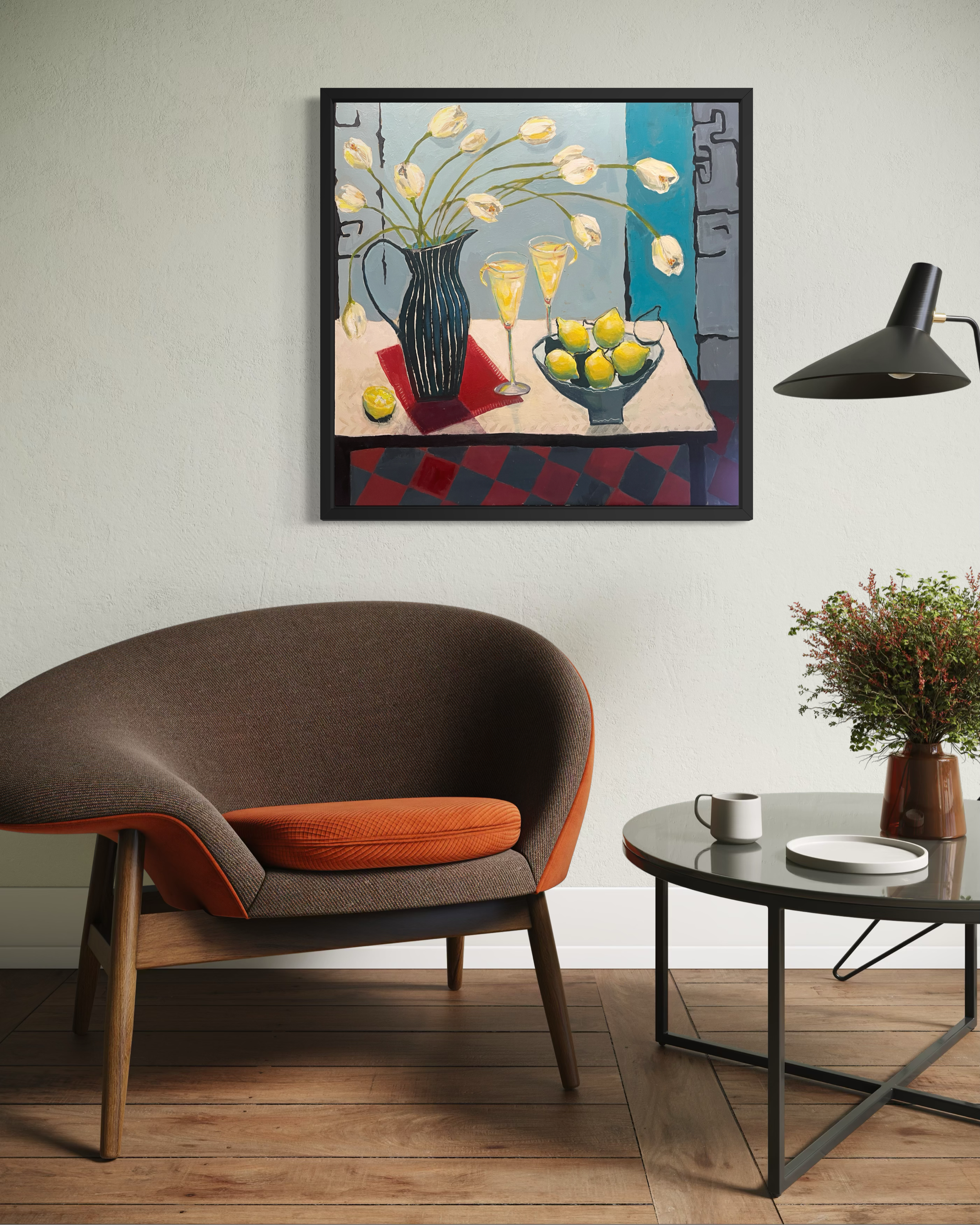 A painting of tulips and lemons hanging on the wall behind a modern bucket armchair and coffee table