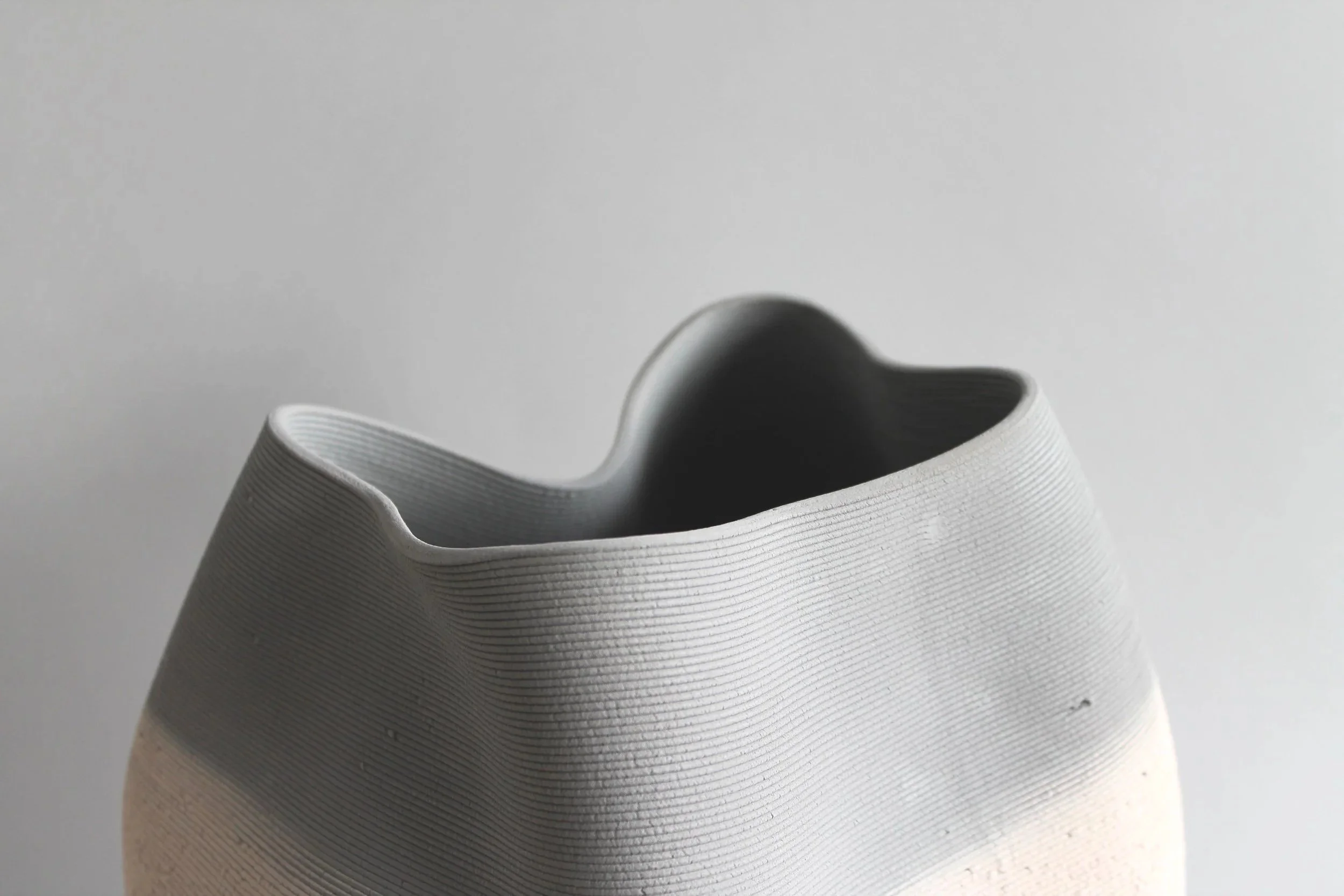 dark grey rim of 3D printed ceramic design pot on grey background