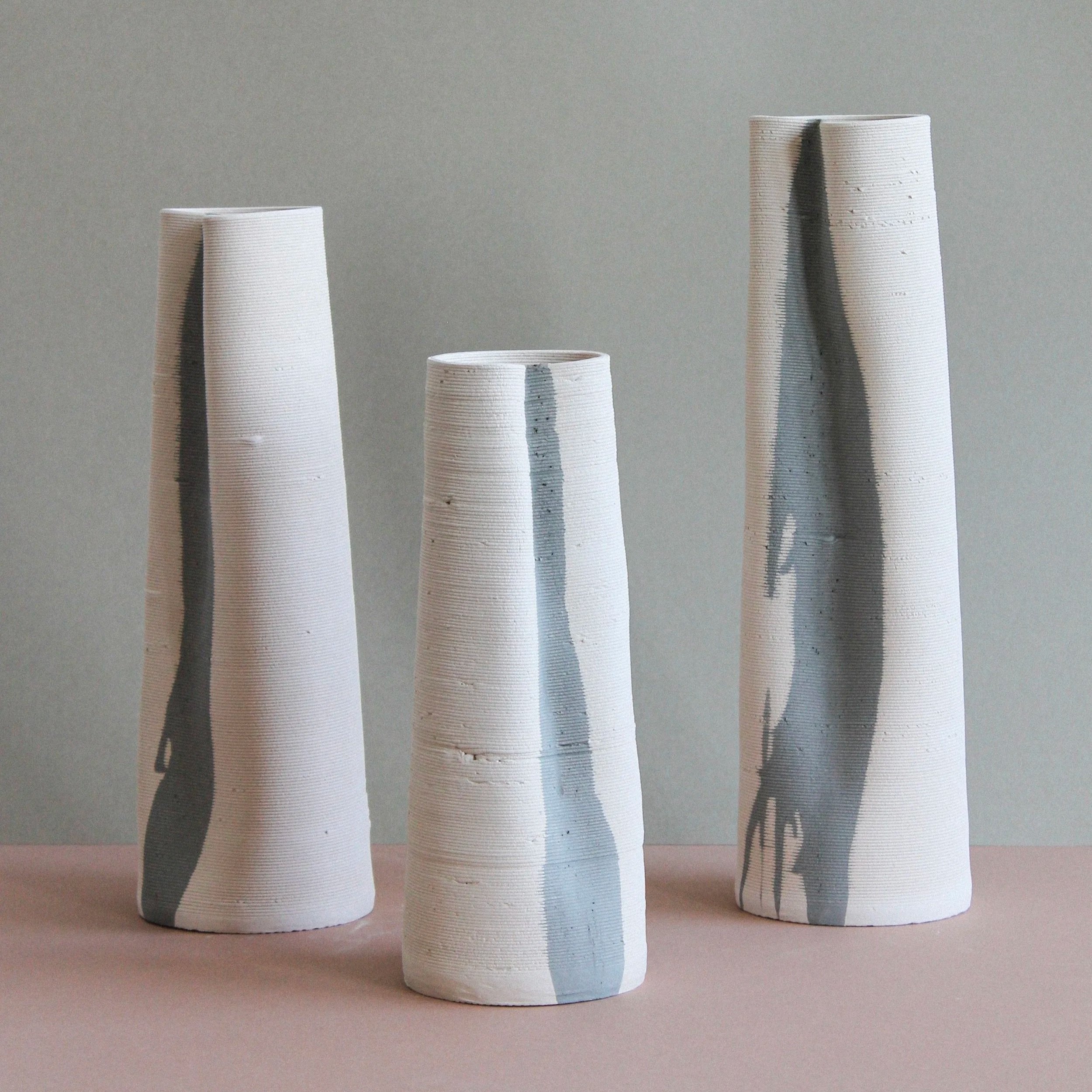 set of three white ceramic vessels in different hights