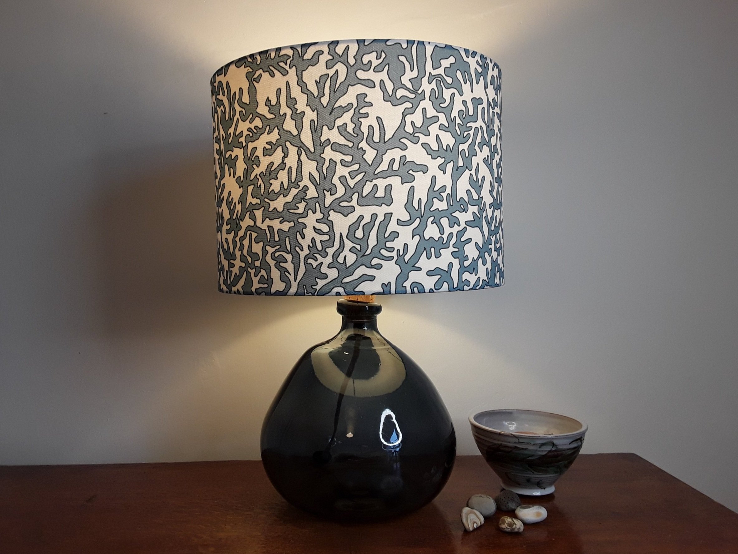 Drum lampshade with coral design in blue on white background.