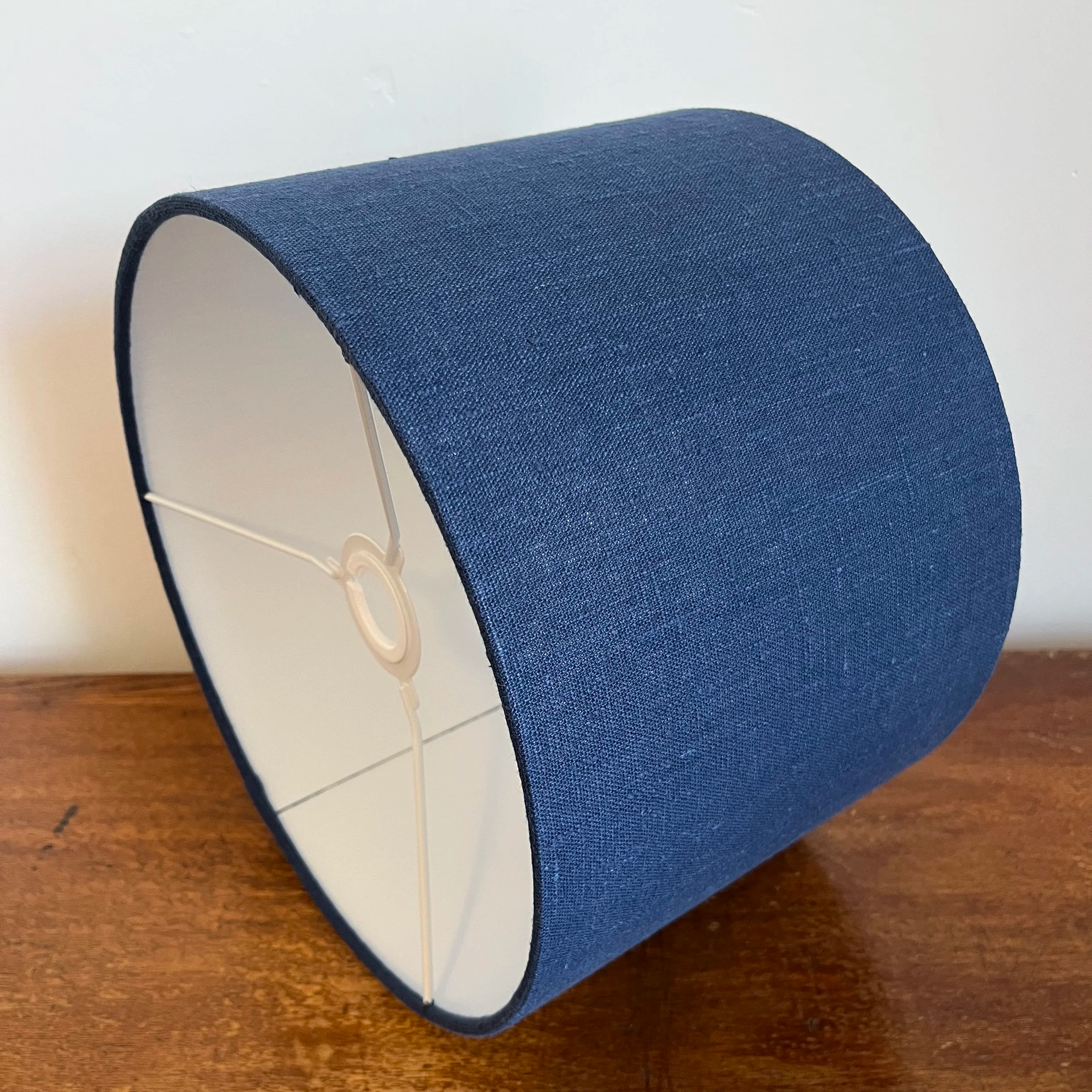 Navy blue linen, drum lamp shade showing white lining and EU to UK fitting.