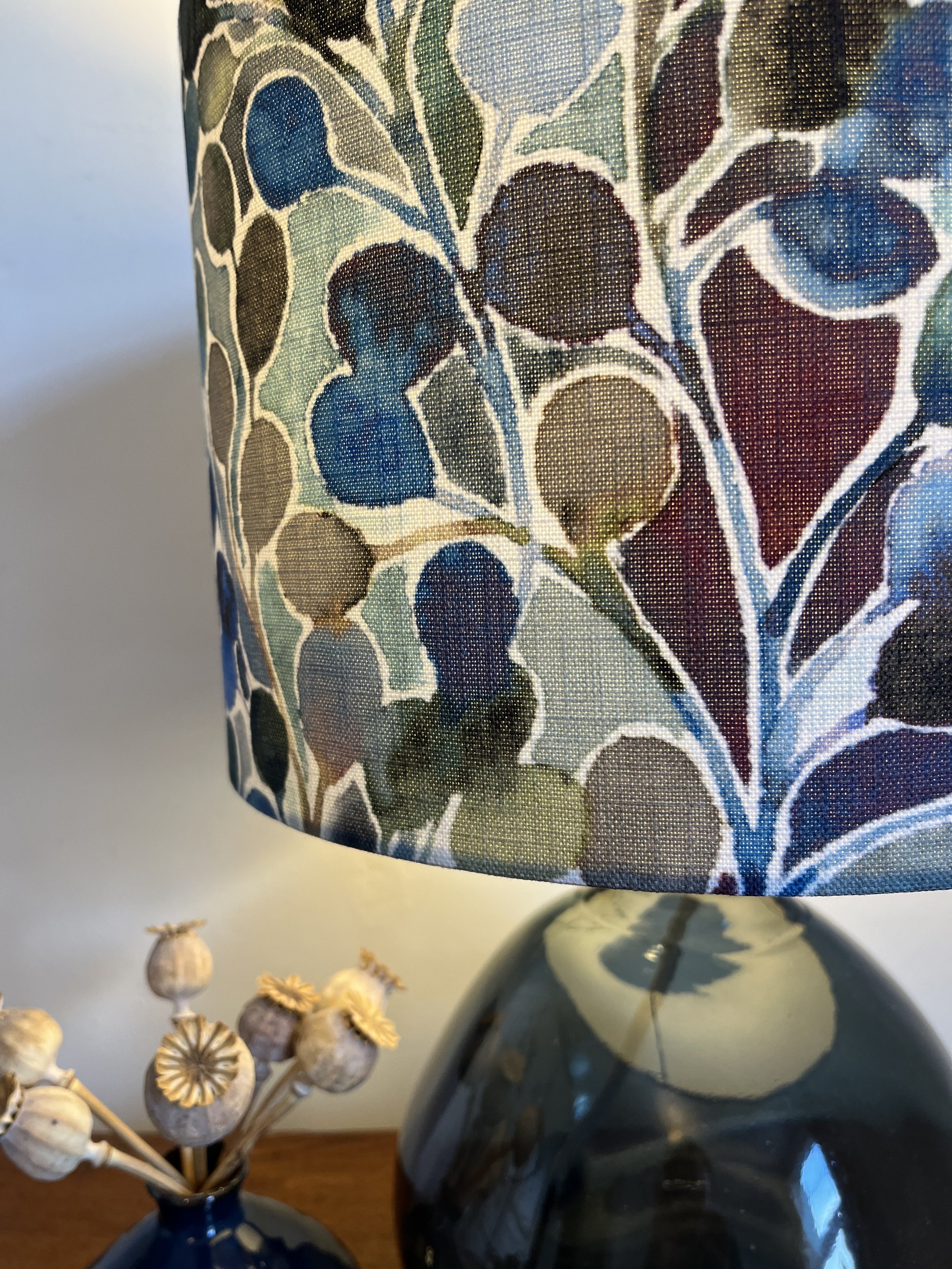 Lampshade, close up of colour and texture of mardi gras fabric in blue, green and plum.