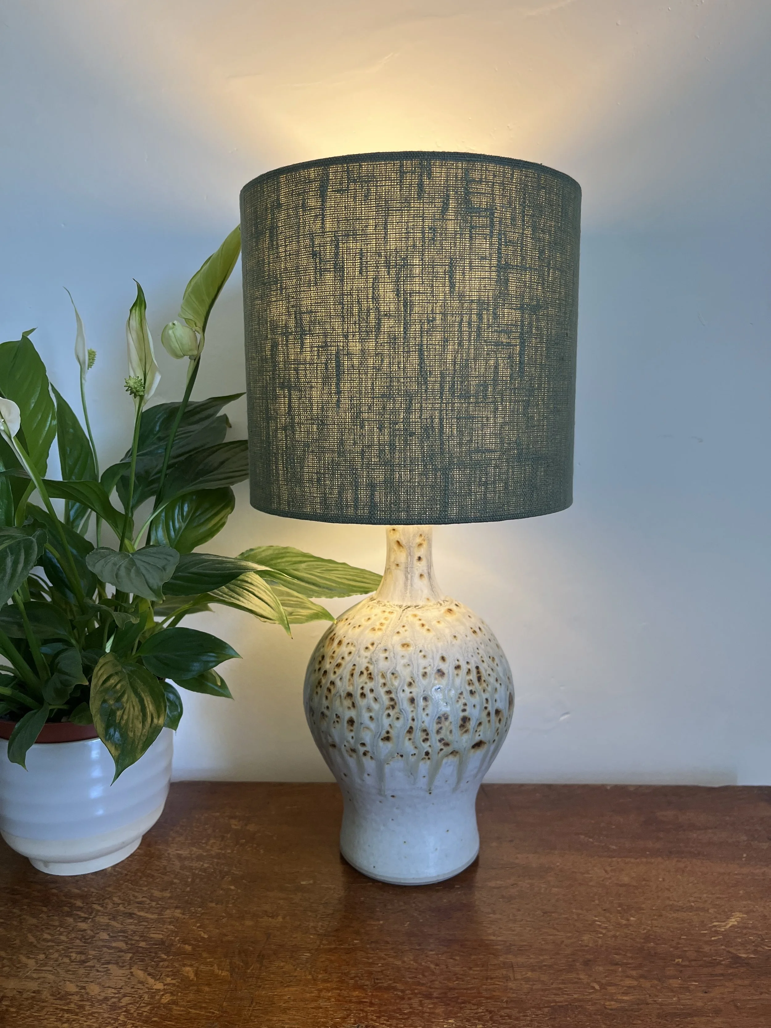 Dark green linen lamp shade, illuminated with the texture of the linen enhanced