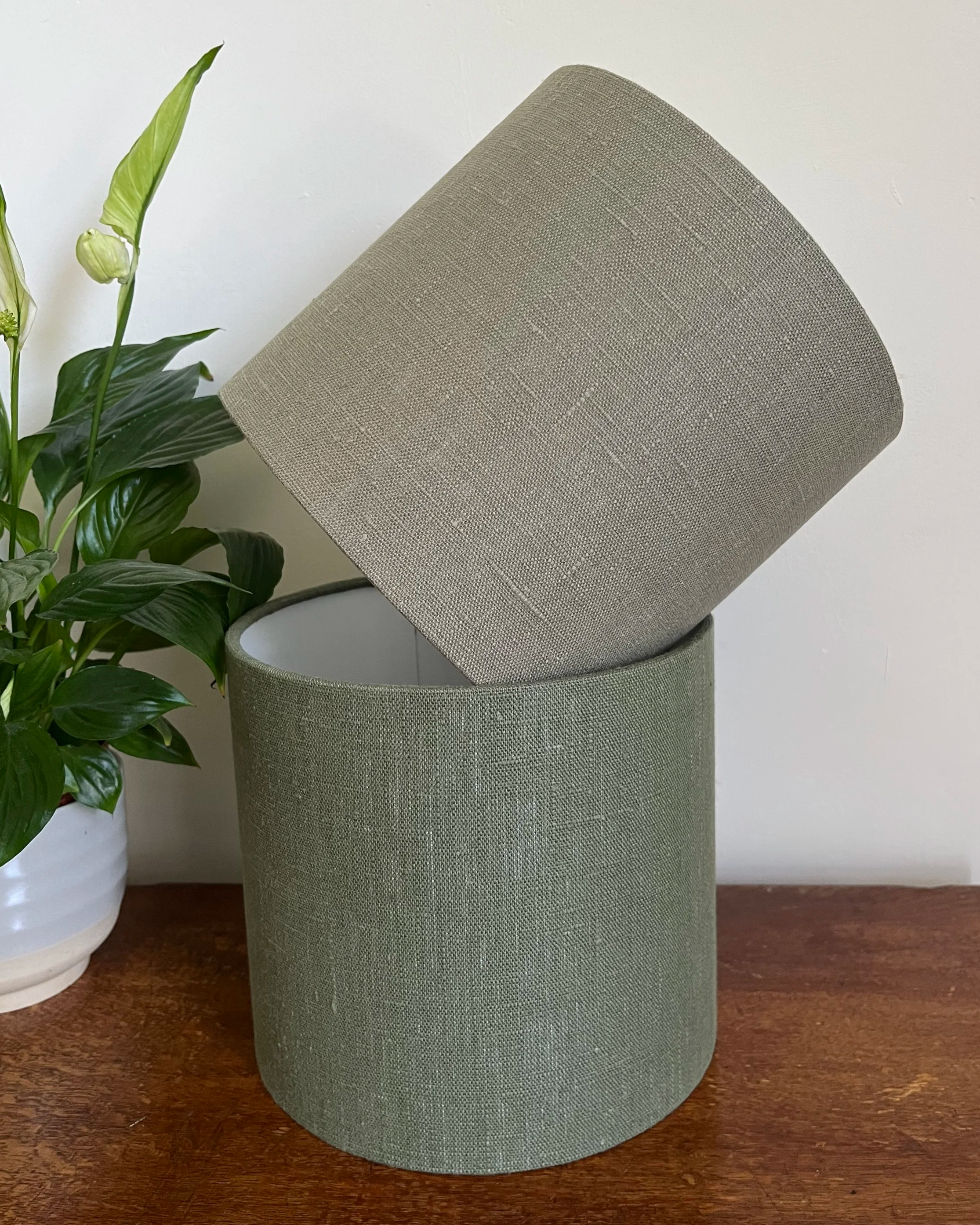 Khaki green linen lampshade on top of a darker green lampshade