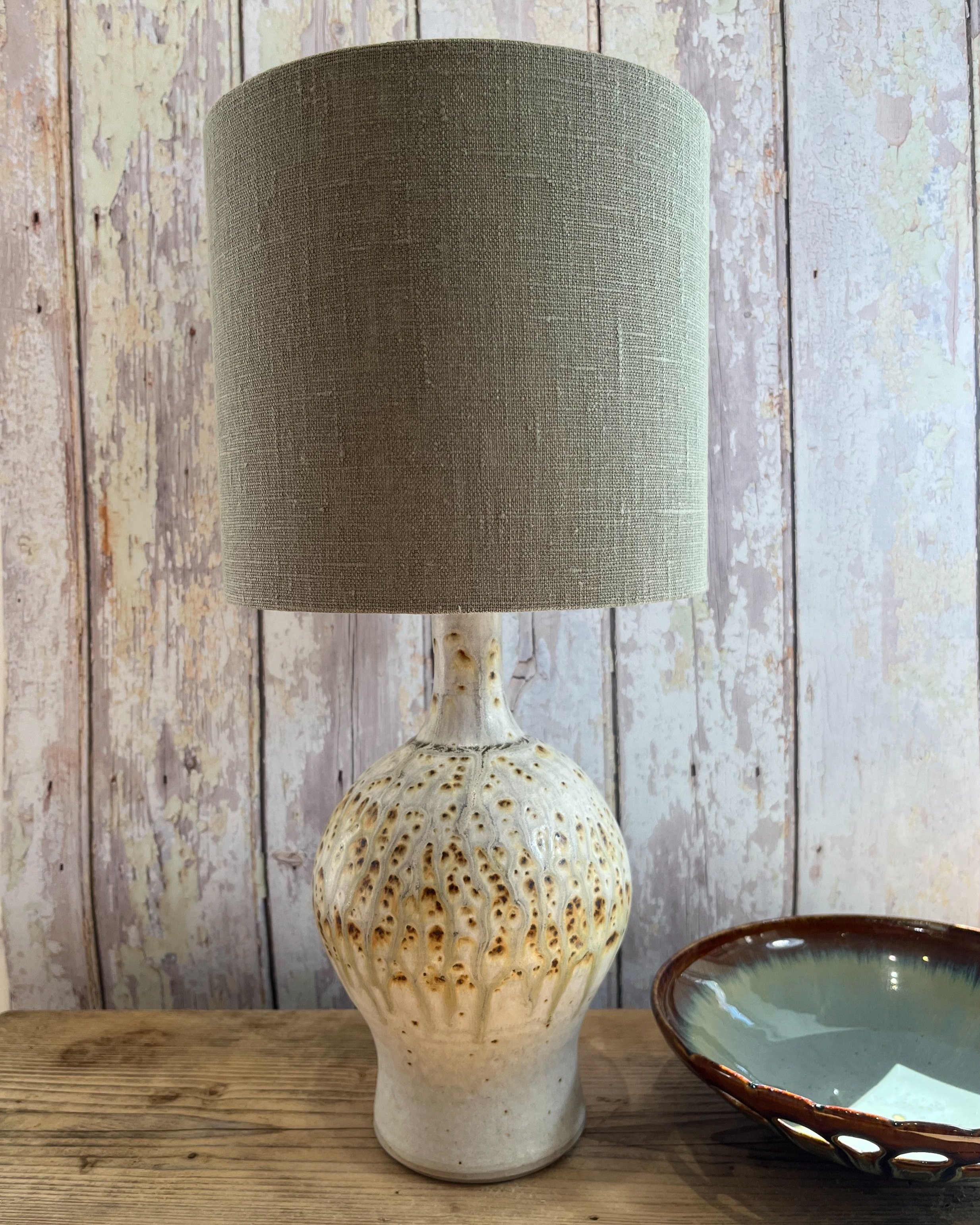 Khaki green linen lampshade, a drum shaped shade with lots of texture.