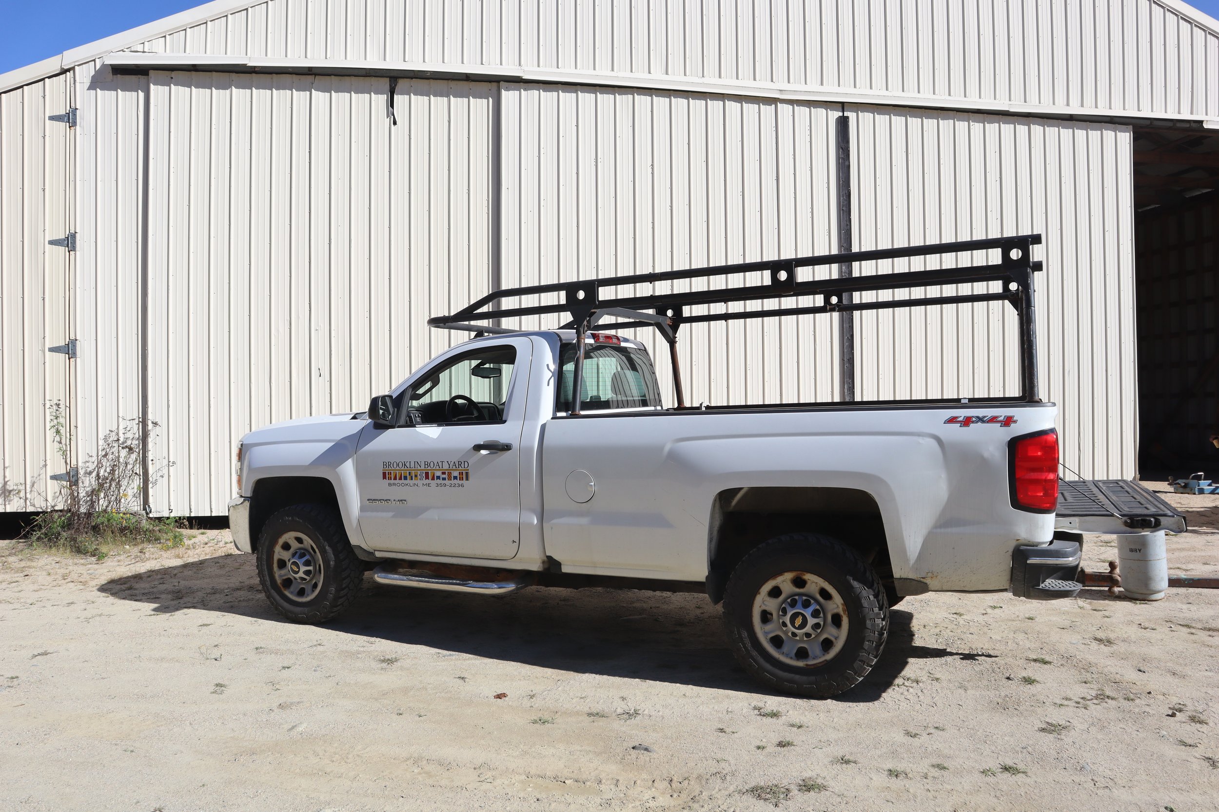 A Brooklin Boat Yard truck outside one storage building.