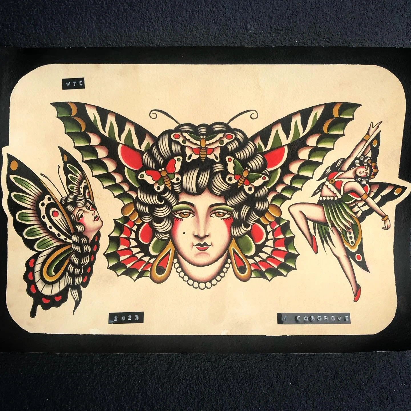 Tattoo artwork featuring a woman's face with butterfly and moth wings as hair, flanked by two butterflies with human faces and butterfly wings, with the artist's name and date.