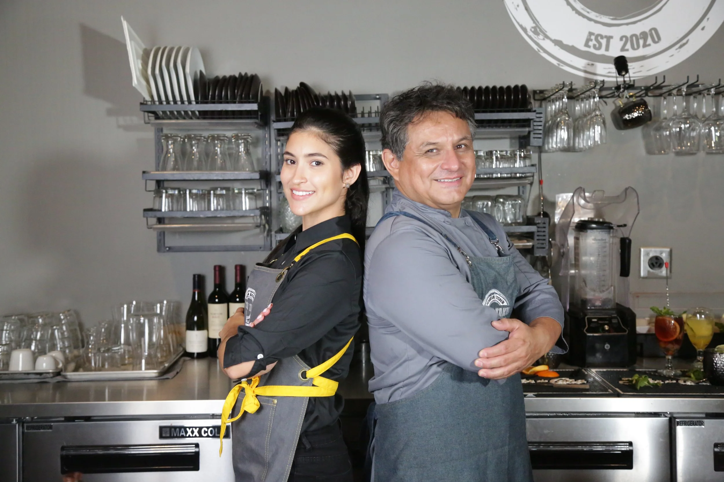 Two Tacu Taku team members smiling in restaurant uniforms.