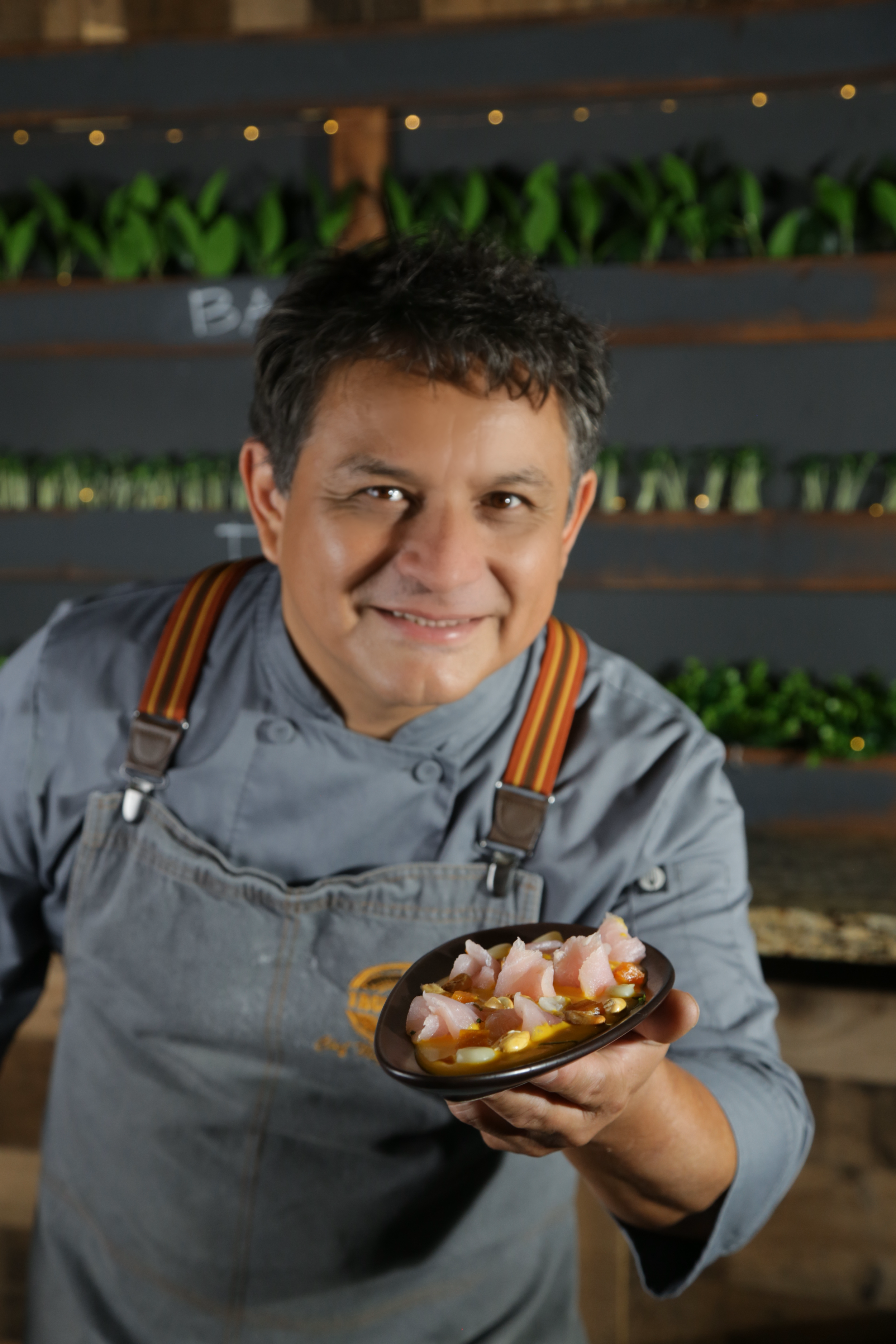 Chef Miguel Cuadros presenting a Peruvian ceviche dish at Tacu Taku.