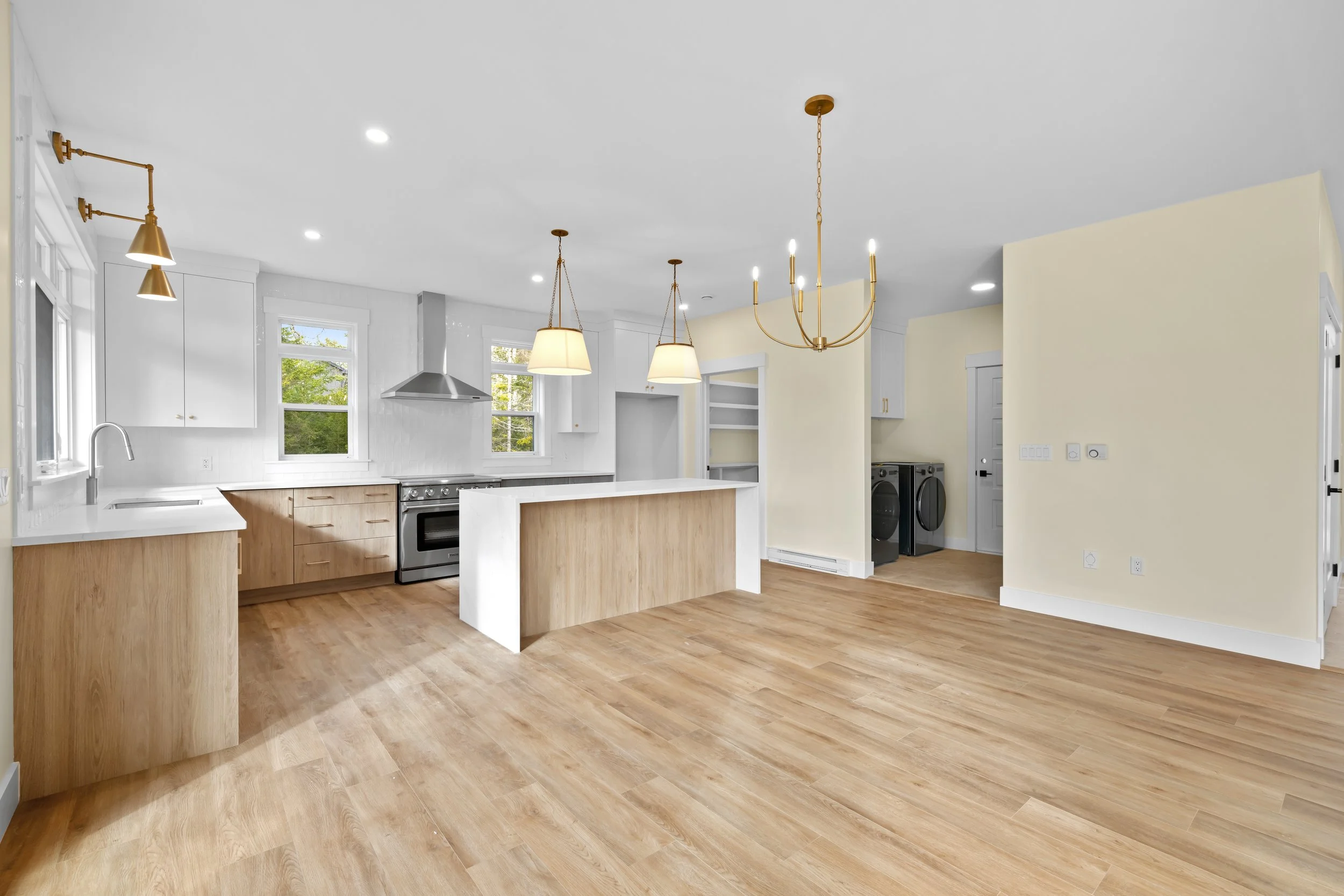 Large kitchen island with plenty of storage and adjacent laundry room