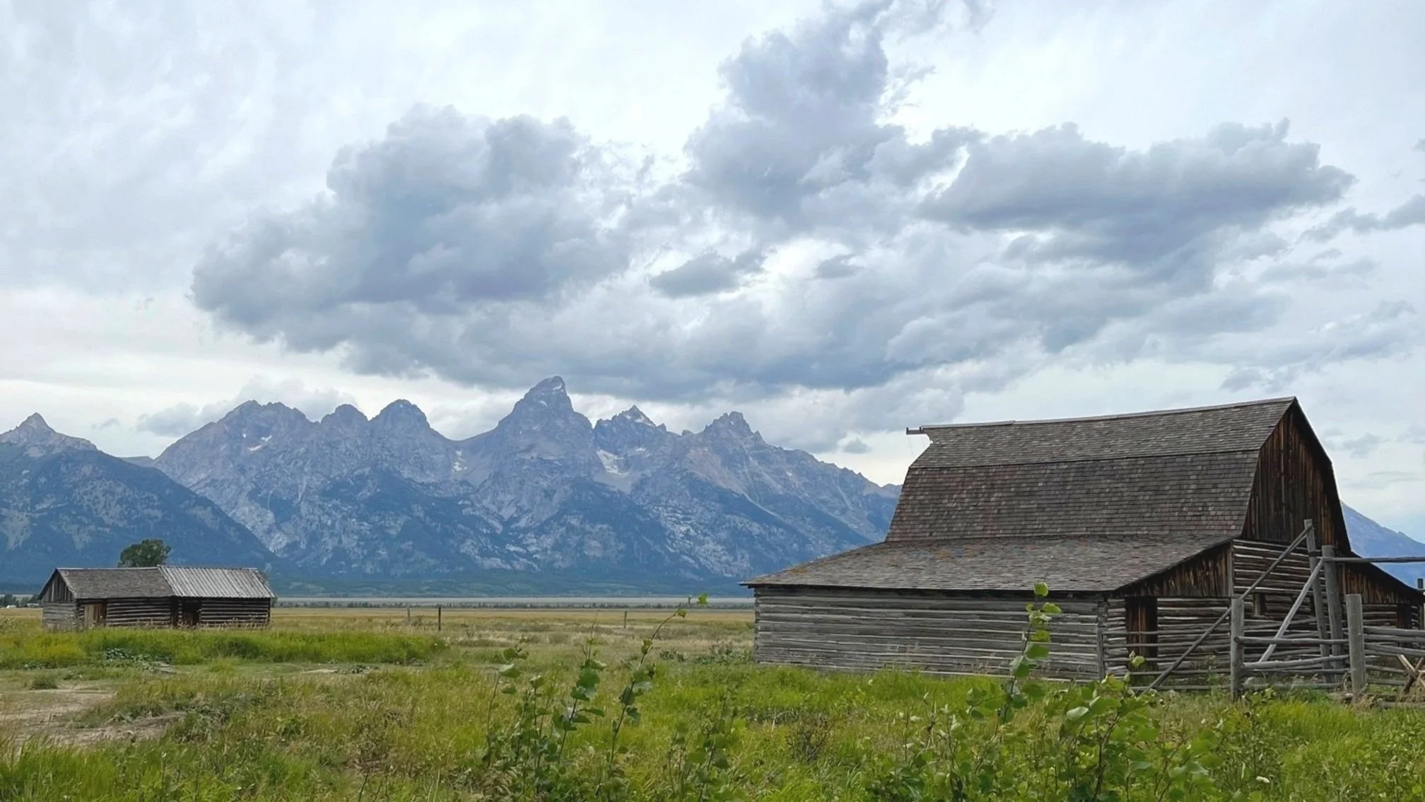 Wooden barn on Mormon Row with Teton mountain range in the background